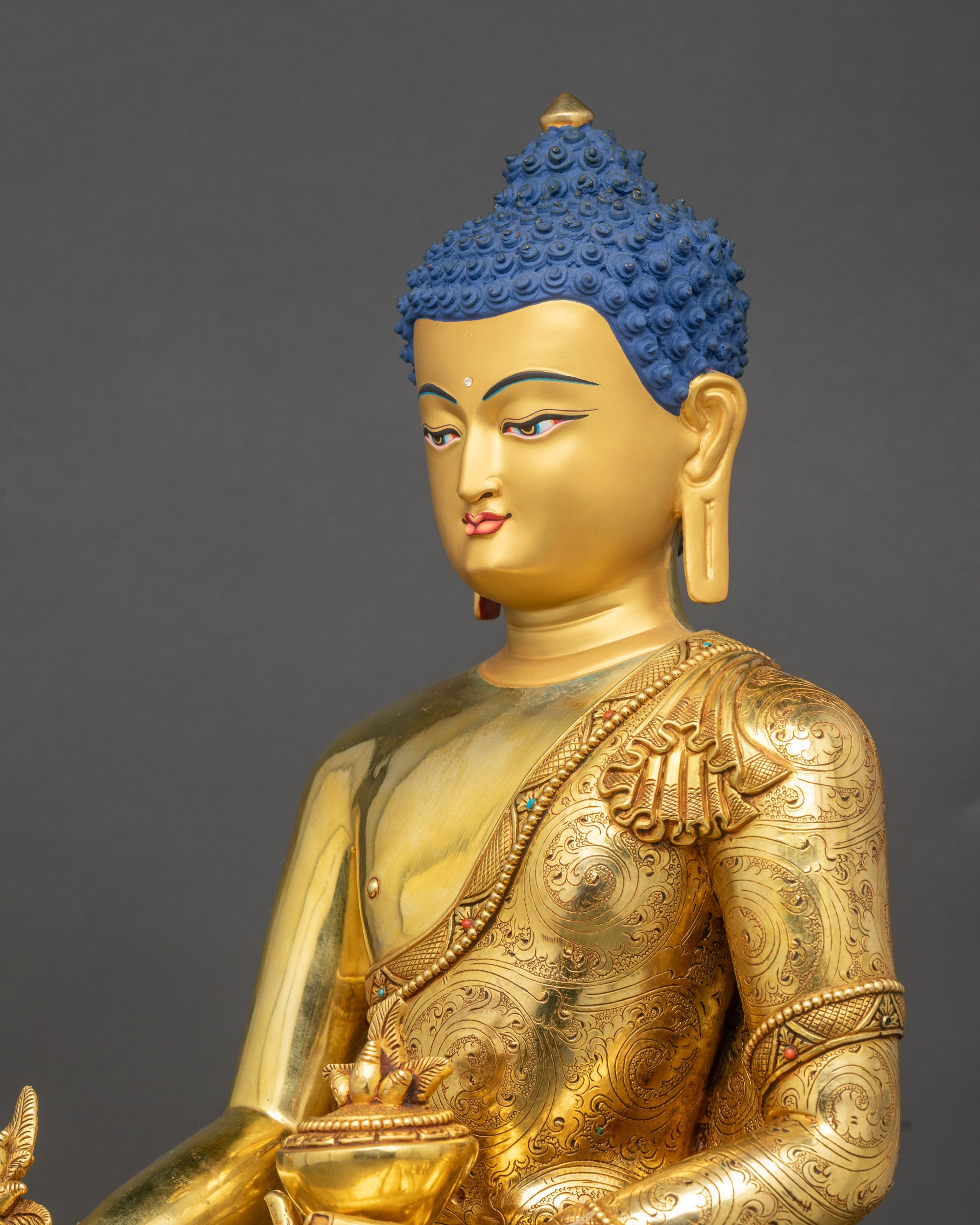 Side close-up of Medicine Buddha highlighting intricate floral robe carvings
