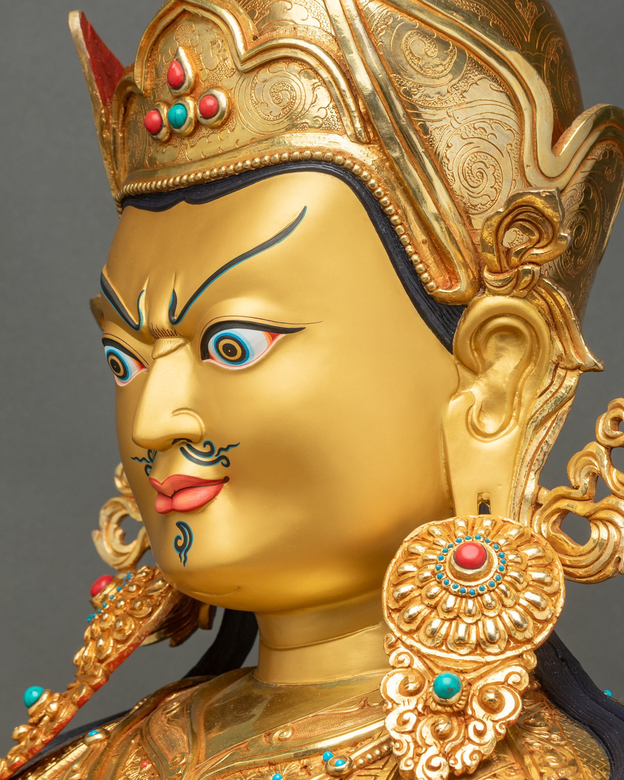 Side close-up of life-size Padmasambhava statue, intricate 3D hand-carved copper detail, gold-painted face Himalayan sculpture