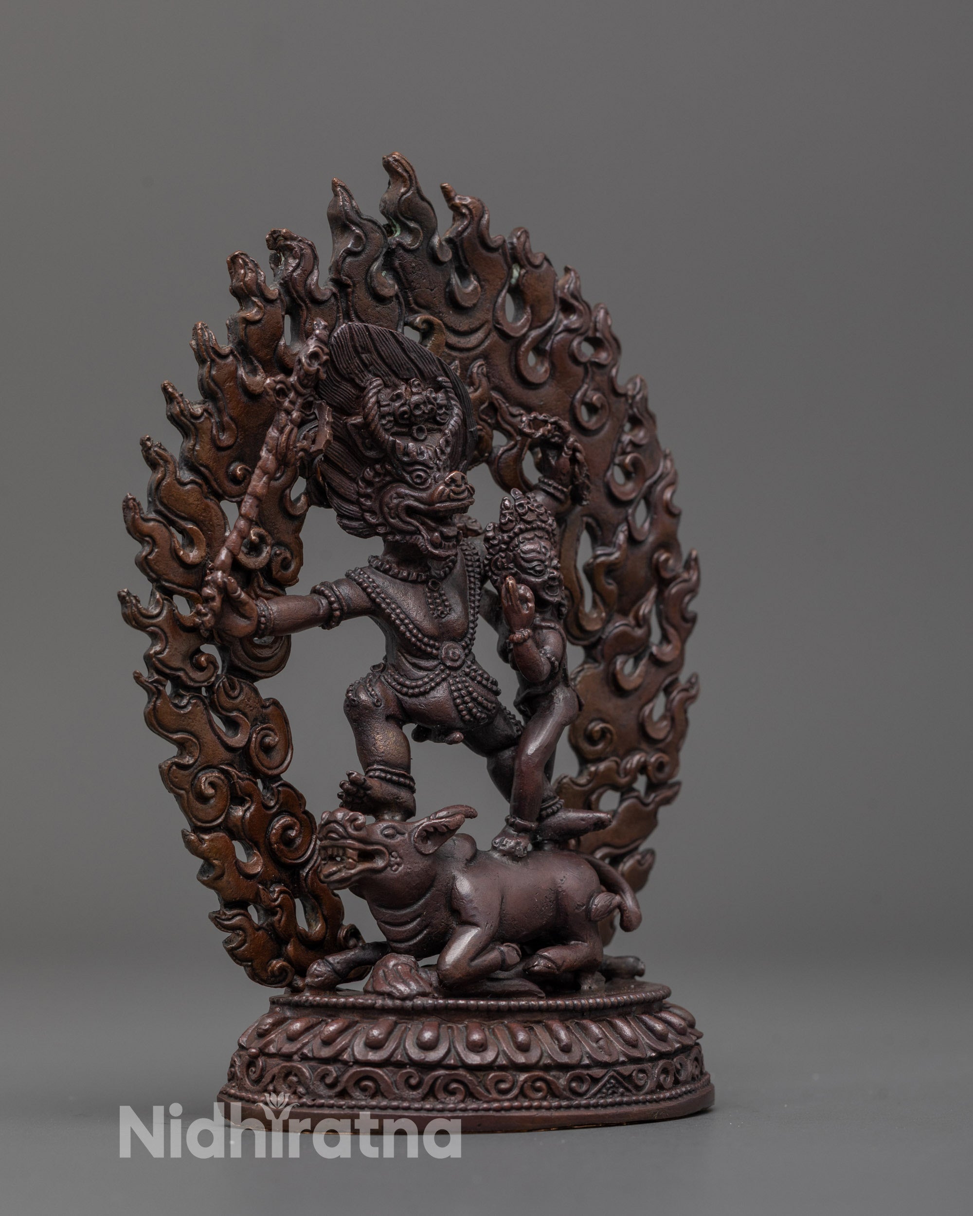 Side close-up of oxidized copper Yama Dharmaraja standing on subdued buffalo