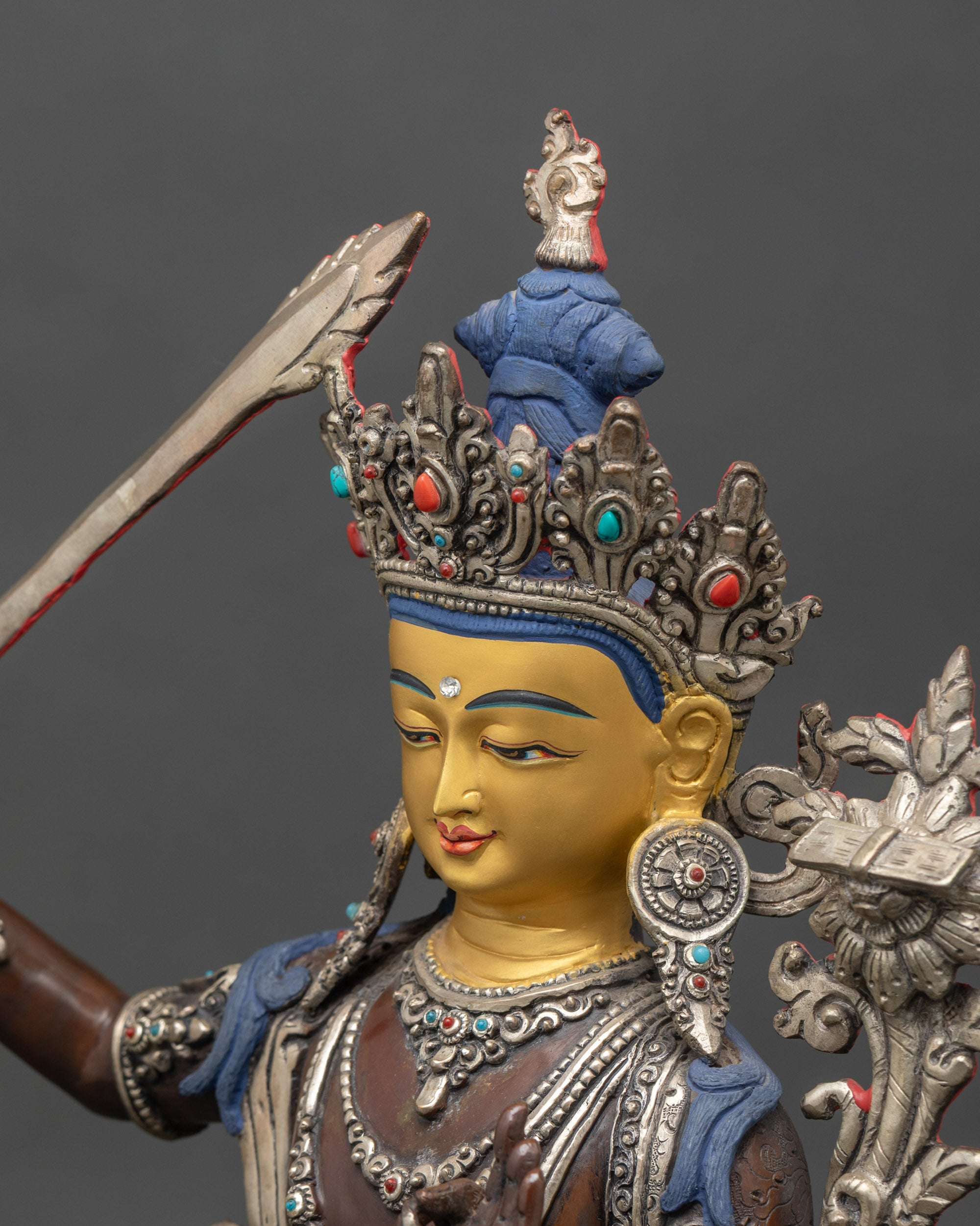 Side close-up showing Manjushri statue sword, utpala flower, and embellishments