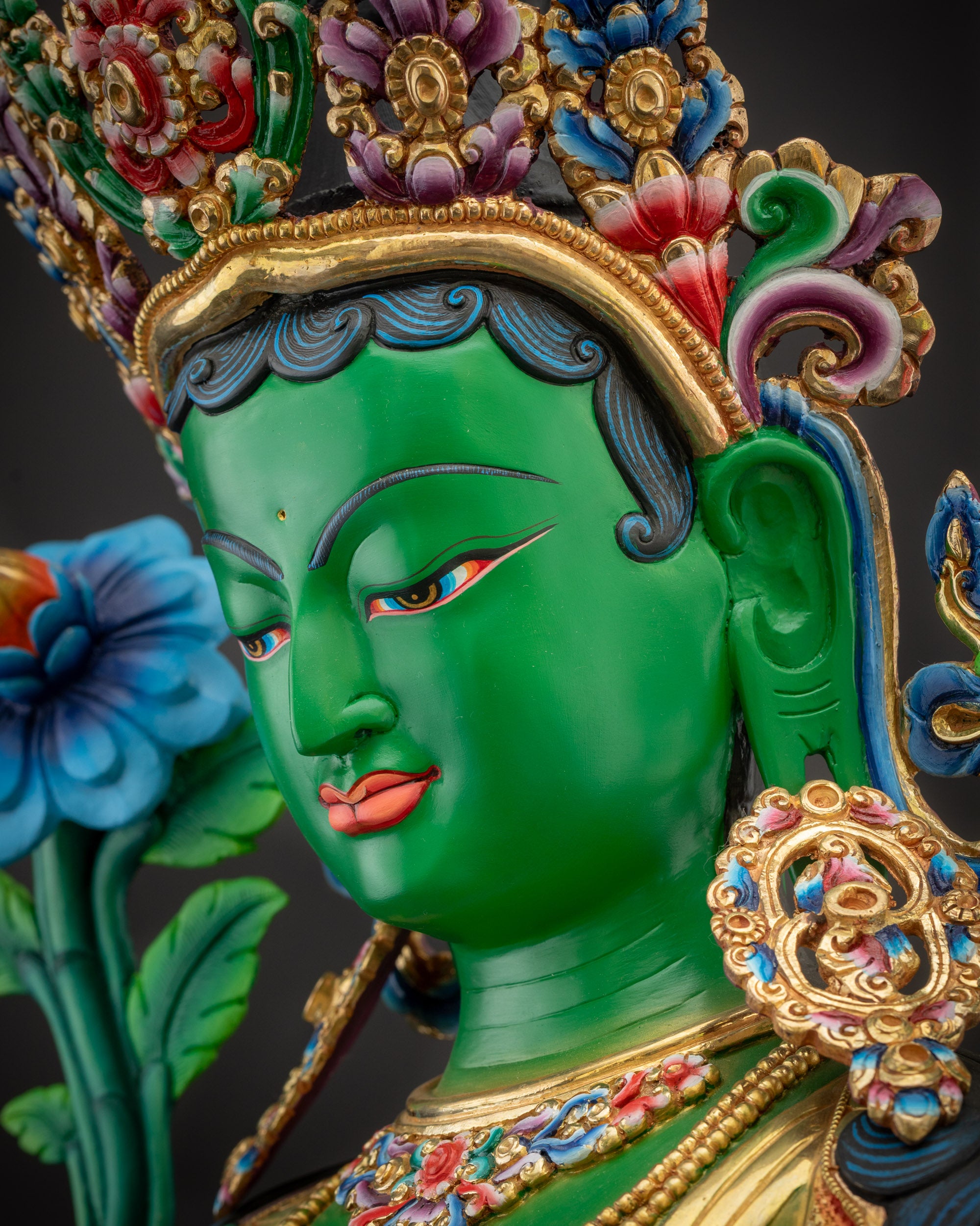 Side close up face Green Tara profile with gold-plated crown and facial details