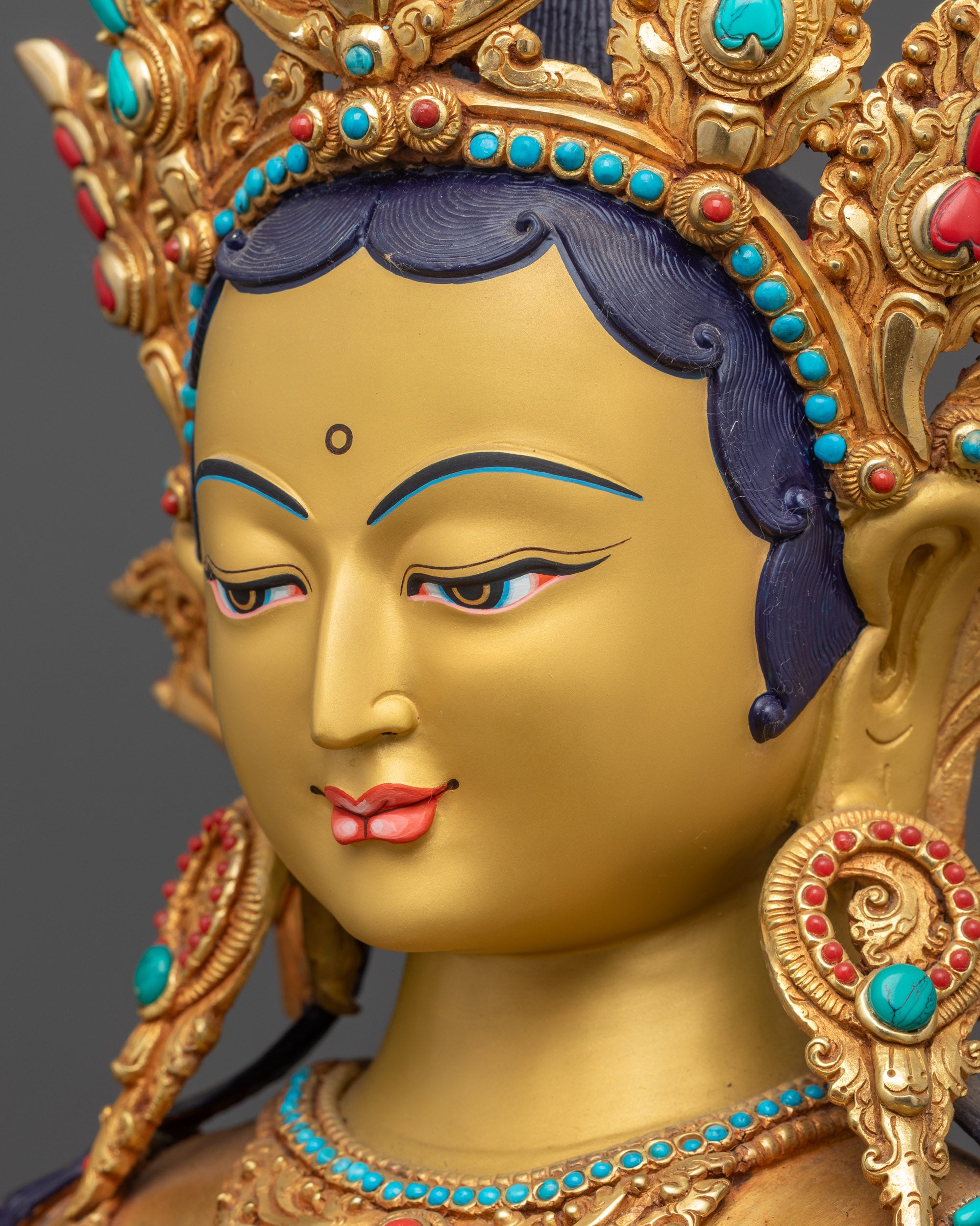 Side close up face Green Tara serene expression with five-jeweled crown visible