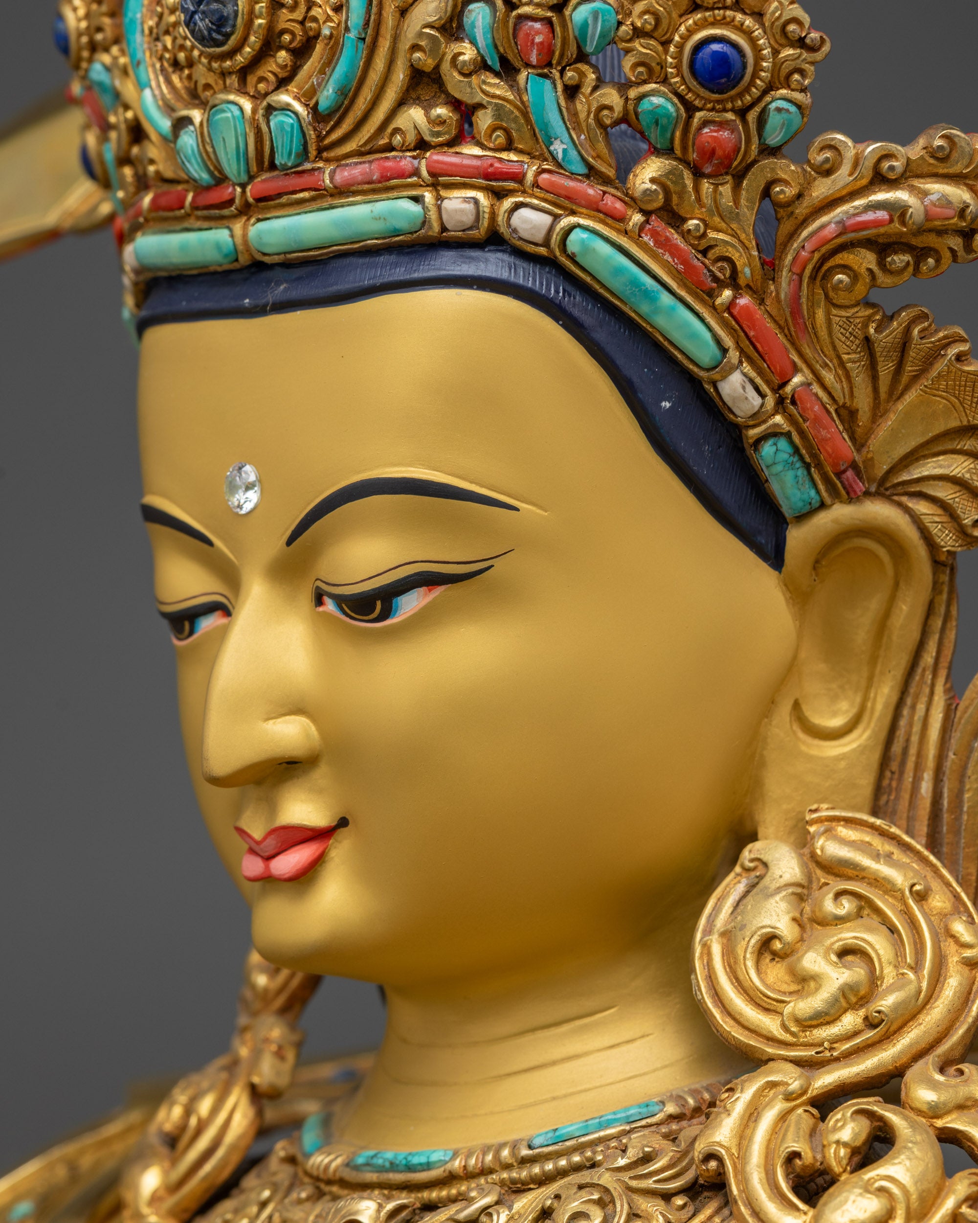 Side close up face of Manjushri statue with tranquil gaze and detailed crown