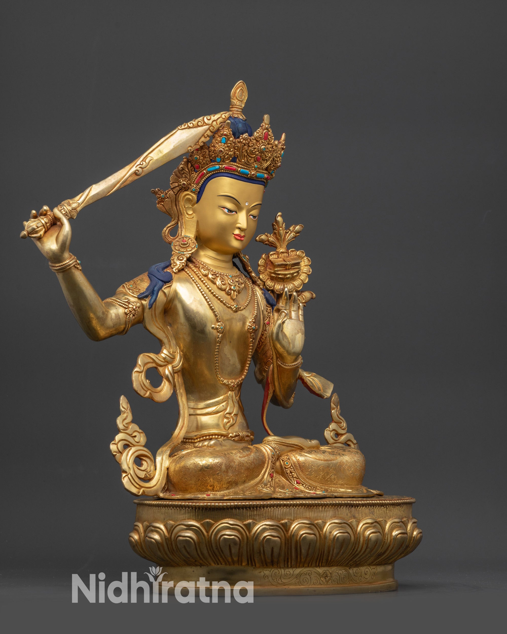 Side close up face of Tibetan Manjushri statue showing intricate robe and peaceful look