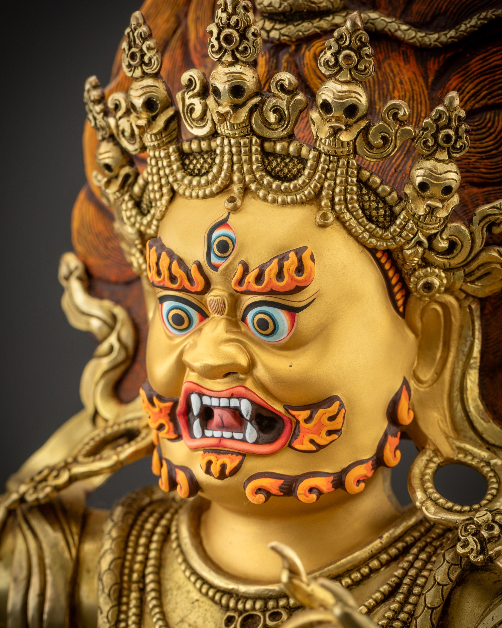 Side close up face of Vajrapani statue with flaming hair and red eyebrows