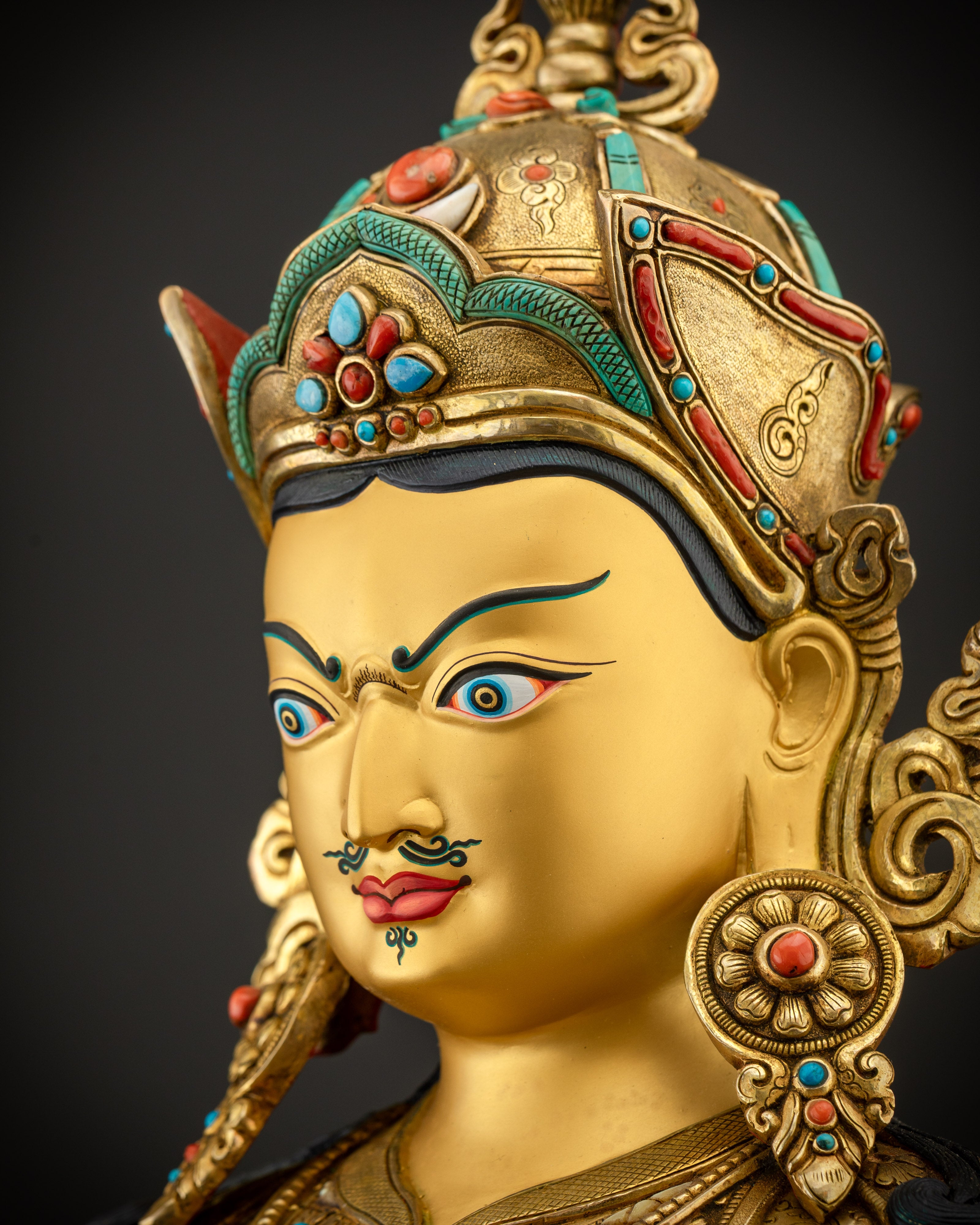 Side close up of Guru Rinpoche face with intricate kasaya patterns and crown details