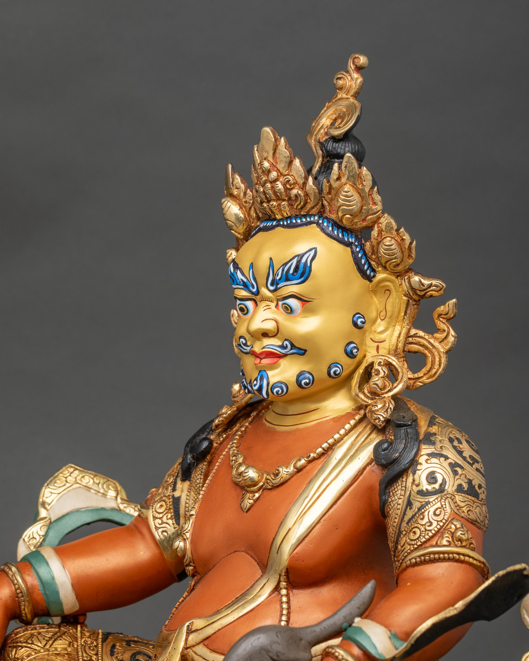 Side detail of Dzambhala statue with halo and jeweled ornaments