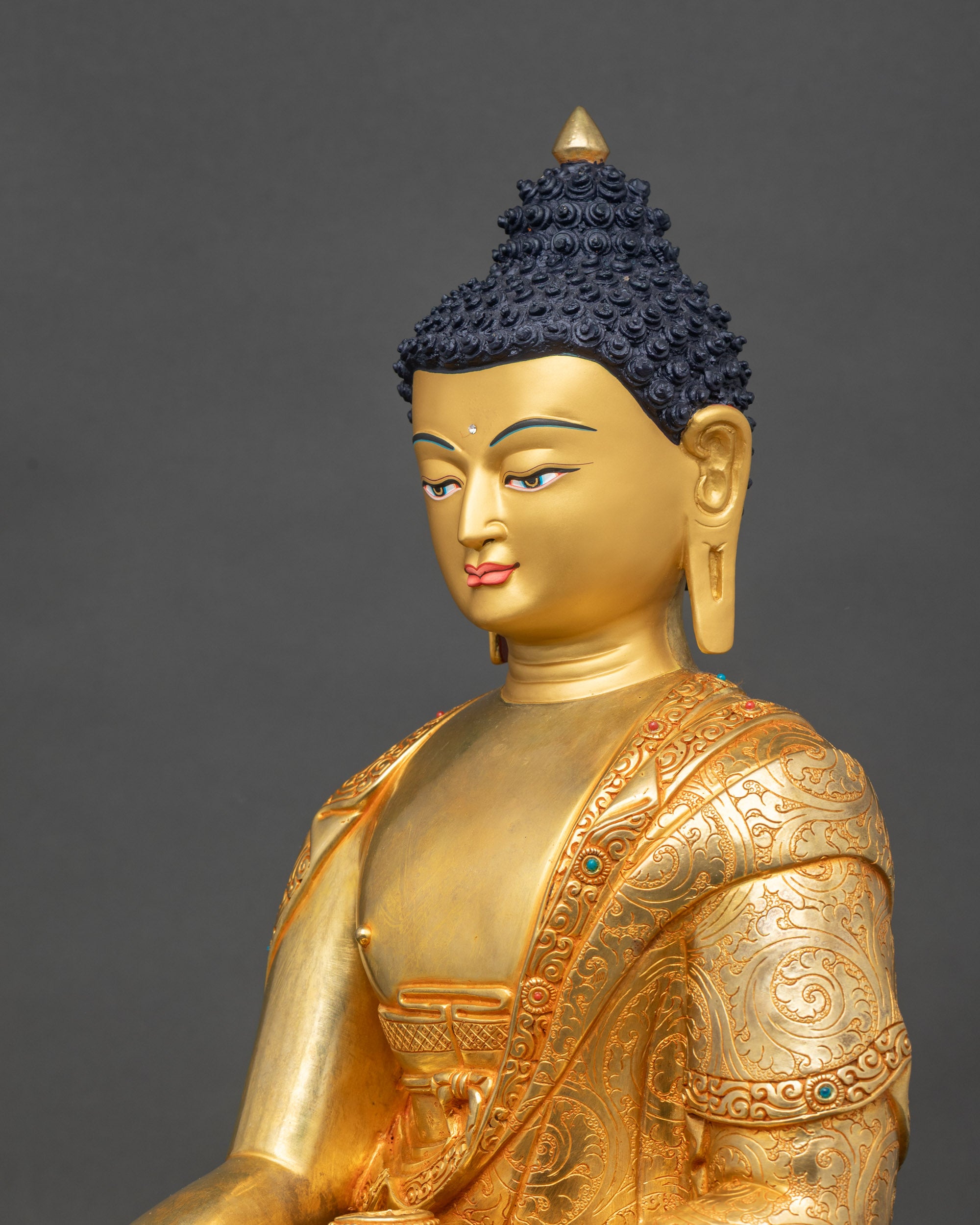 Side detail of Shakyamuni Buddha statue with floral robe carvings and stones