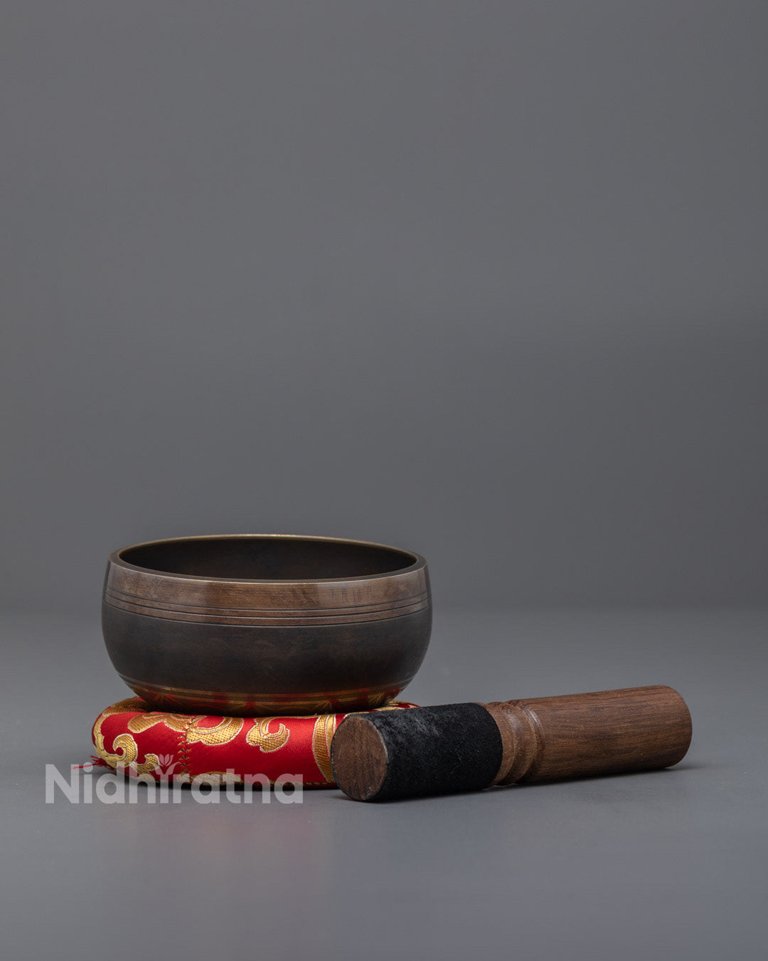 Side image of Singing Bowl set with wooden striker and brocade cushion, perfect for sound therapy