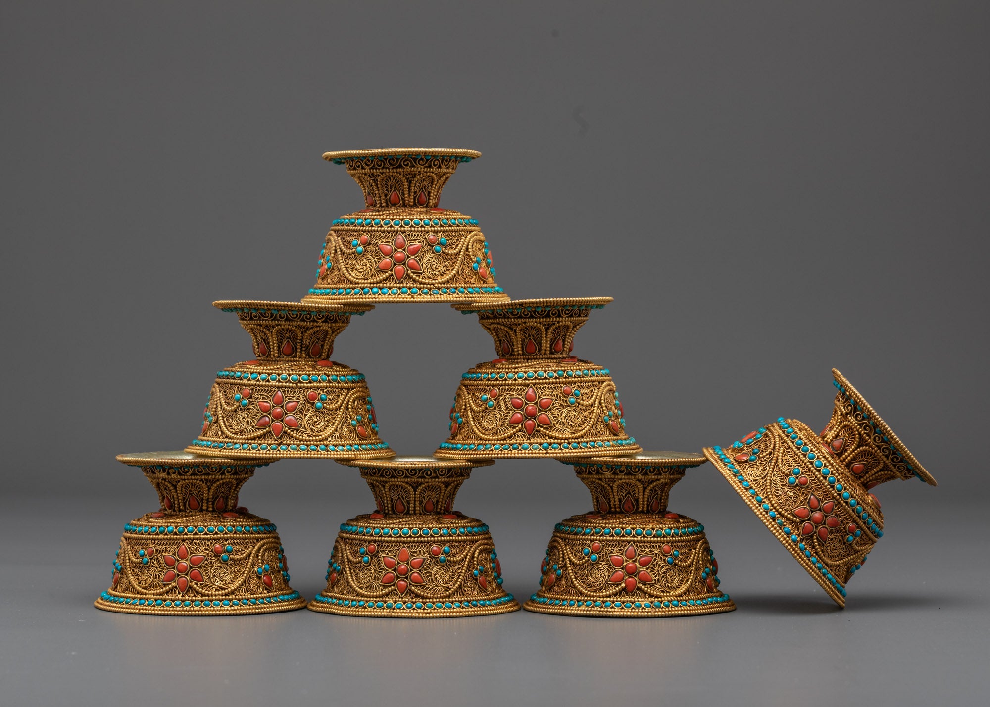 Side profile of silver-base Buddhist offering bowl with gold filigree and stone