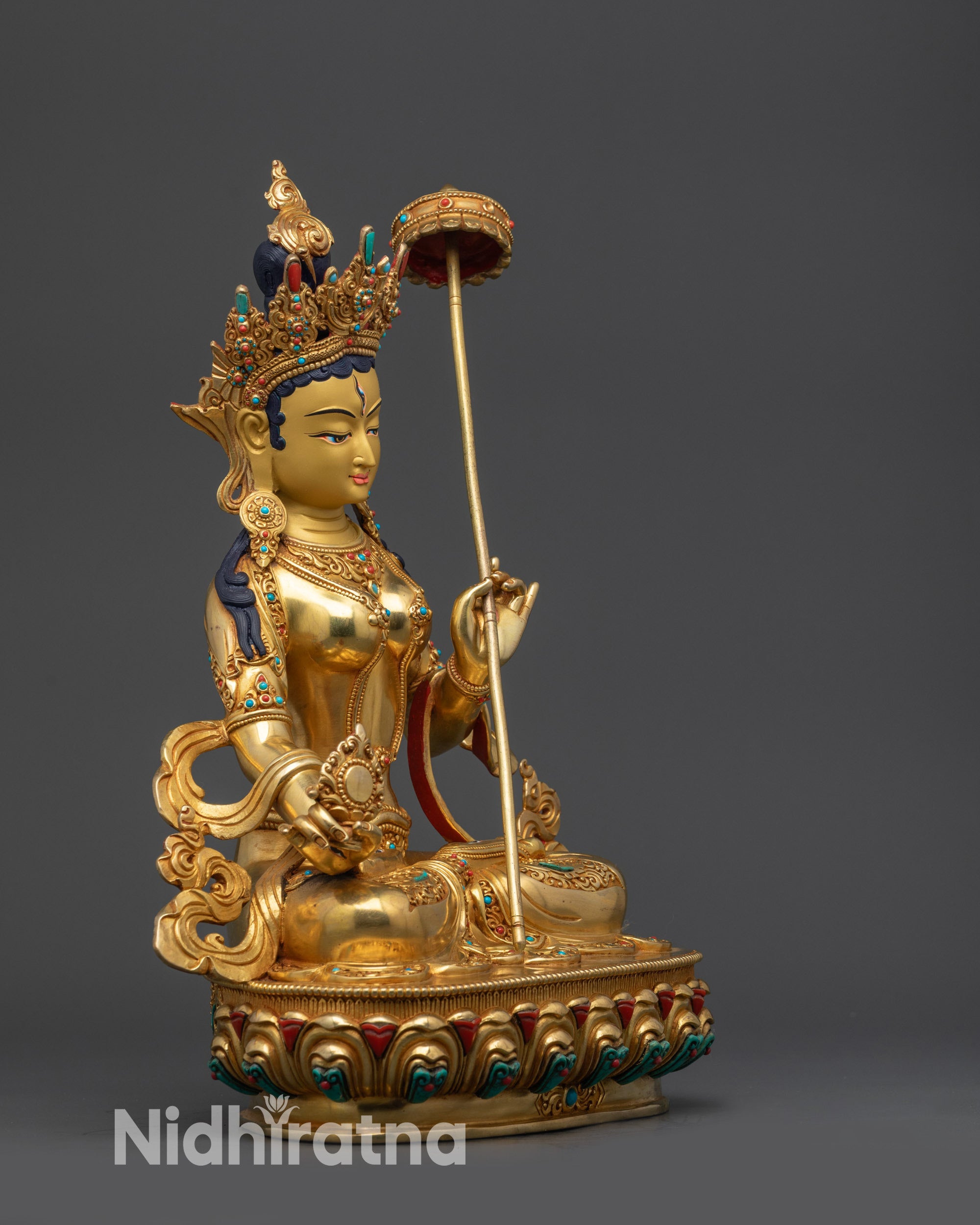 Side view Dukar Statue showing umbrella, crown, and intricately carved lower garments