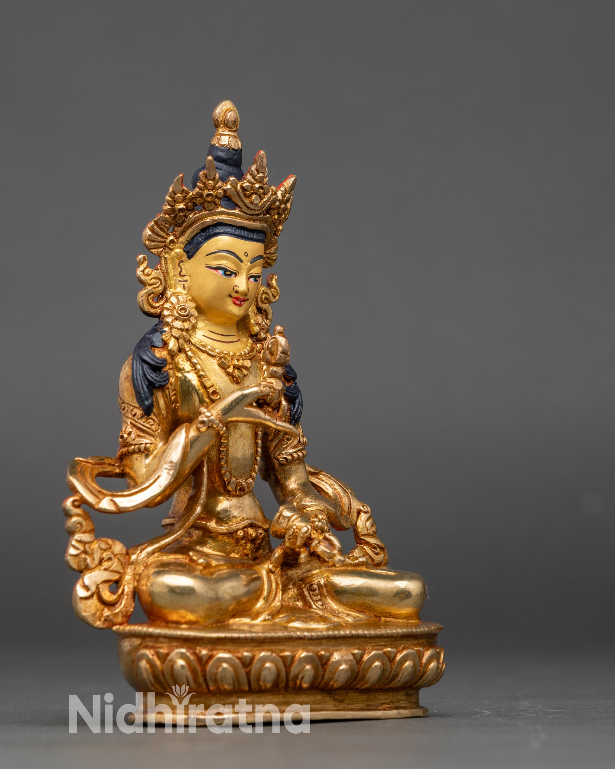 Side view Gold Vajrasattva Buddha statue vajra and bell mudra meditation pose