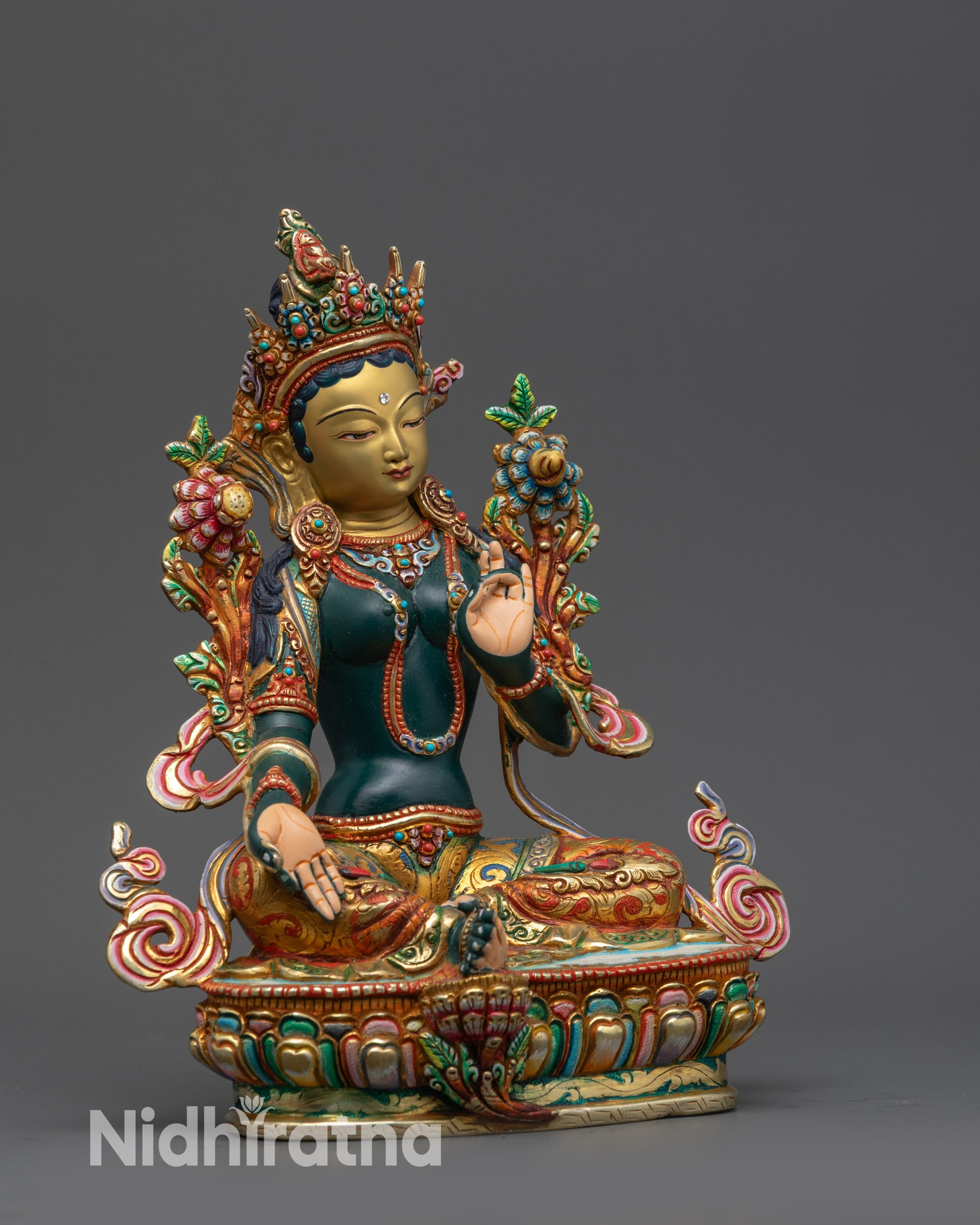 Side view Green Tara Sculpture showing royal ease pose and extended foot on lotus
