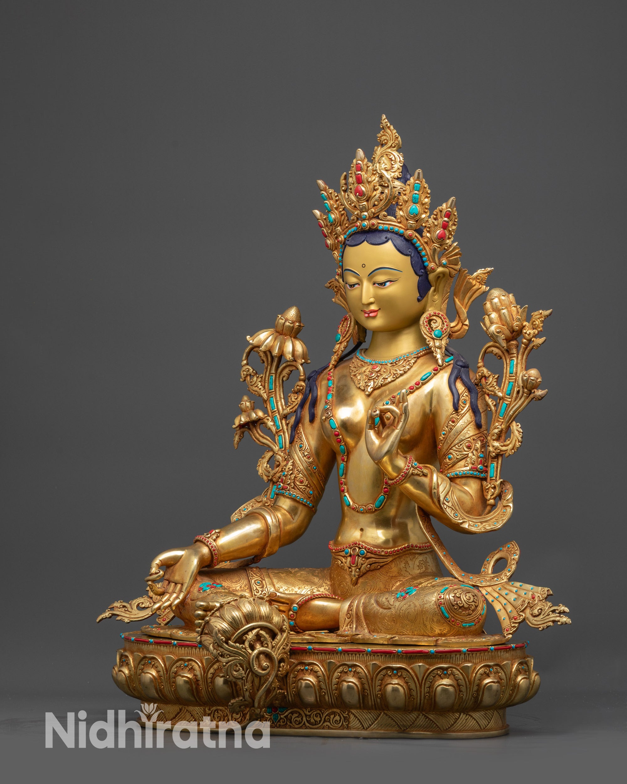 Side view Green Tara gold-gilded statue seated on lotus in royal ease posture