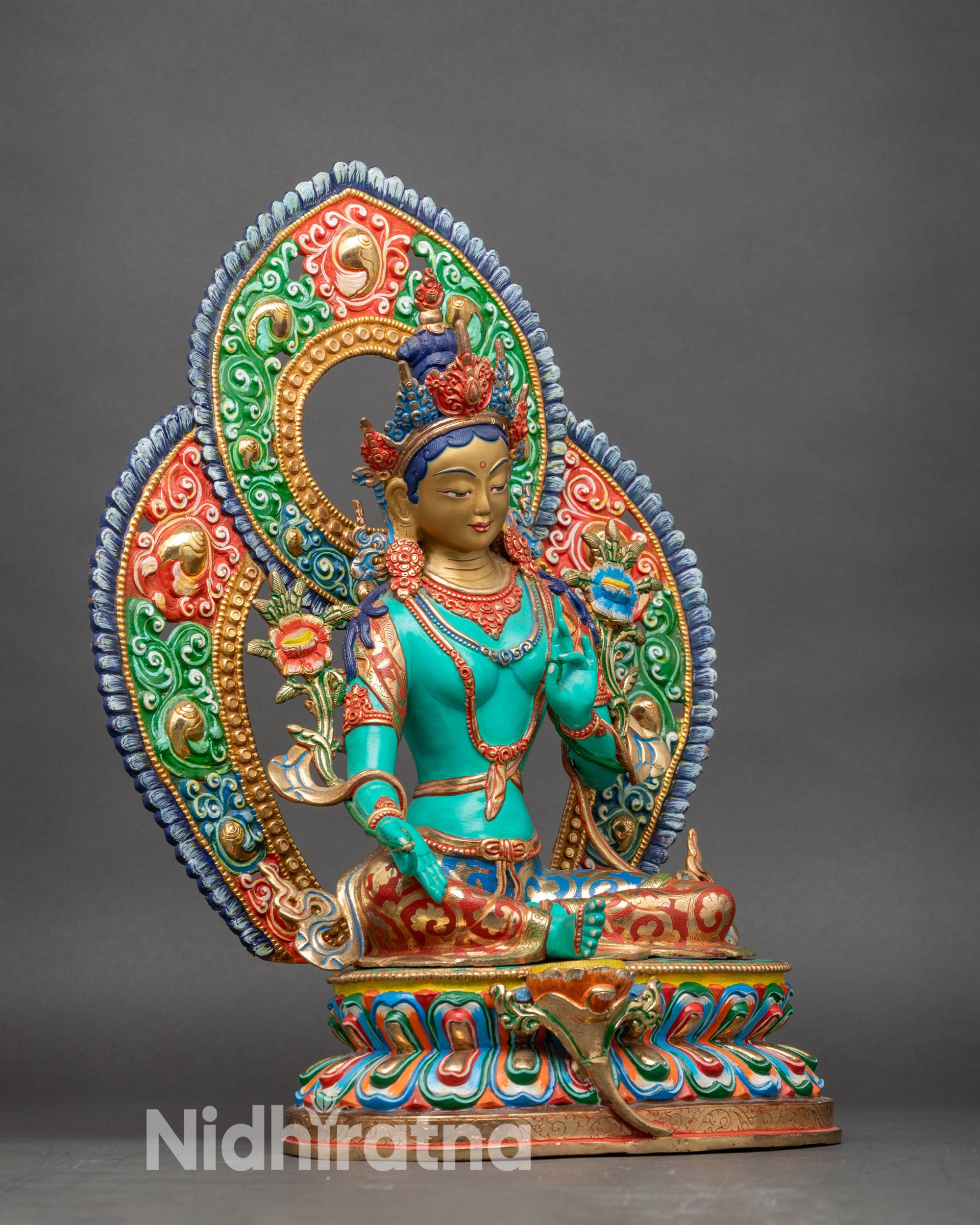 Side view Green Tara seated on multicolored double lotus with floral and scroll halo