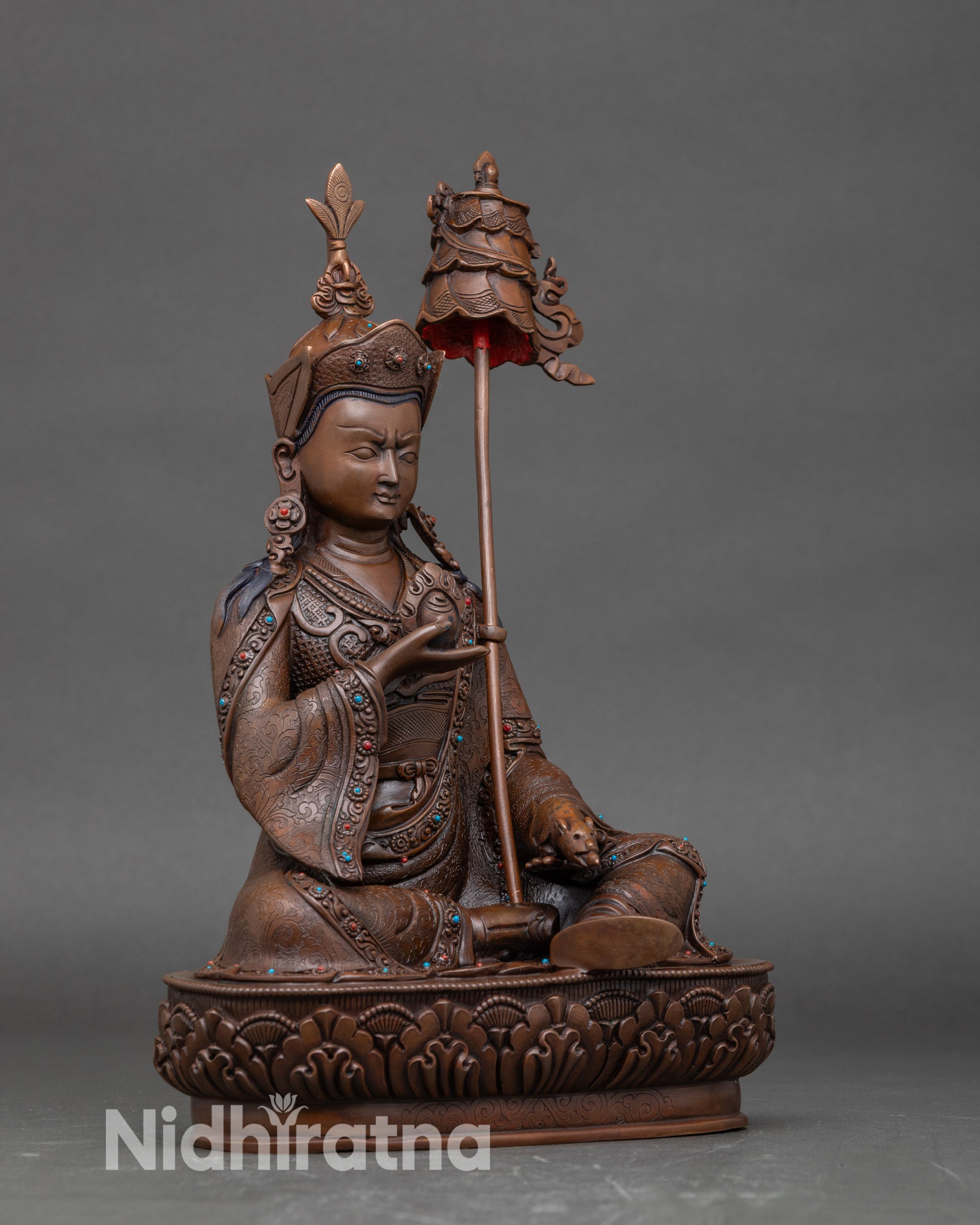 Side view Guru Norlha statue with victory banner on shoulder, lotus pedestal detail