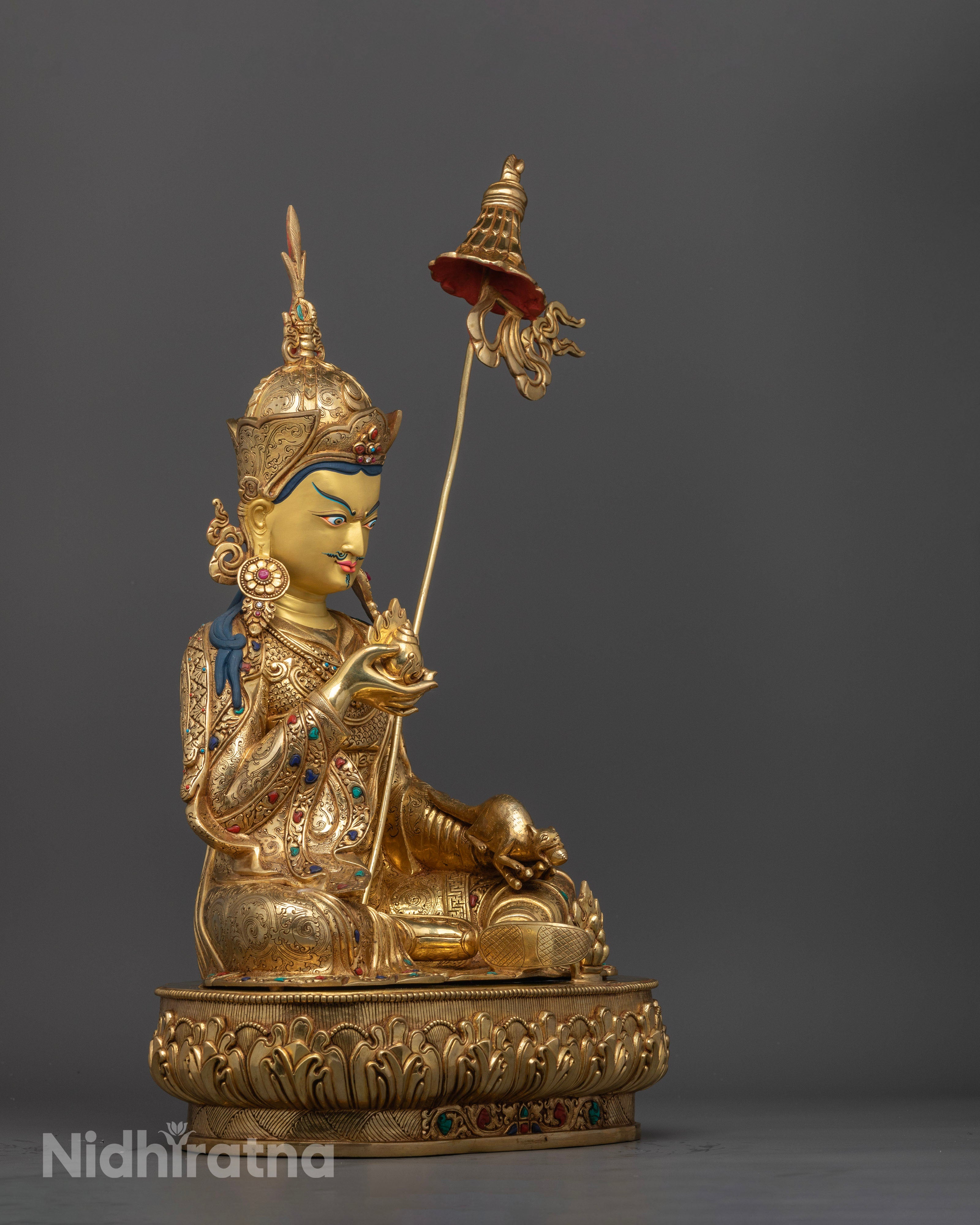 Side view Guru Orgyen Norlha statue holding chintamani jewel and jewel-spitting mongoose, Nepalese copper artwork