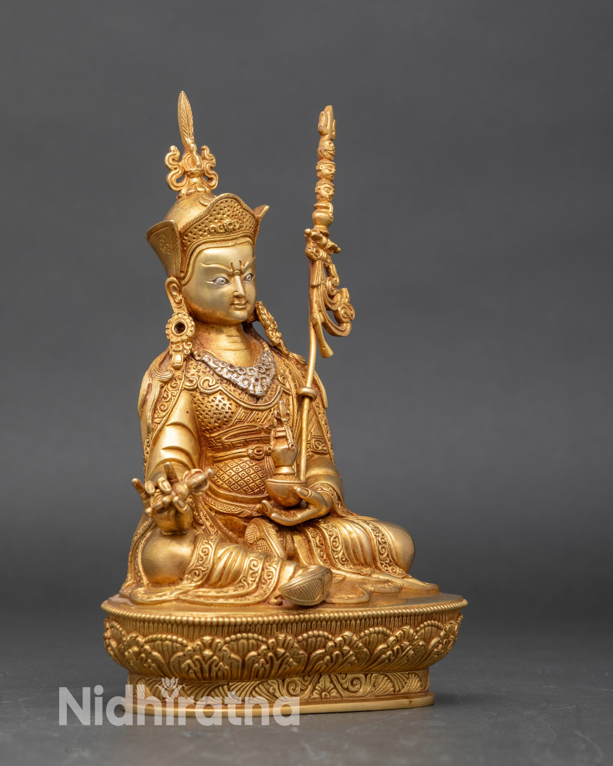 Side view Guru Rinpoche sculpture holding skull cup and Dorje with Khatvanga