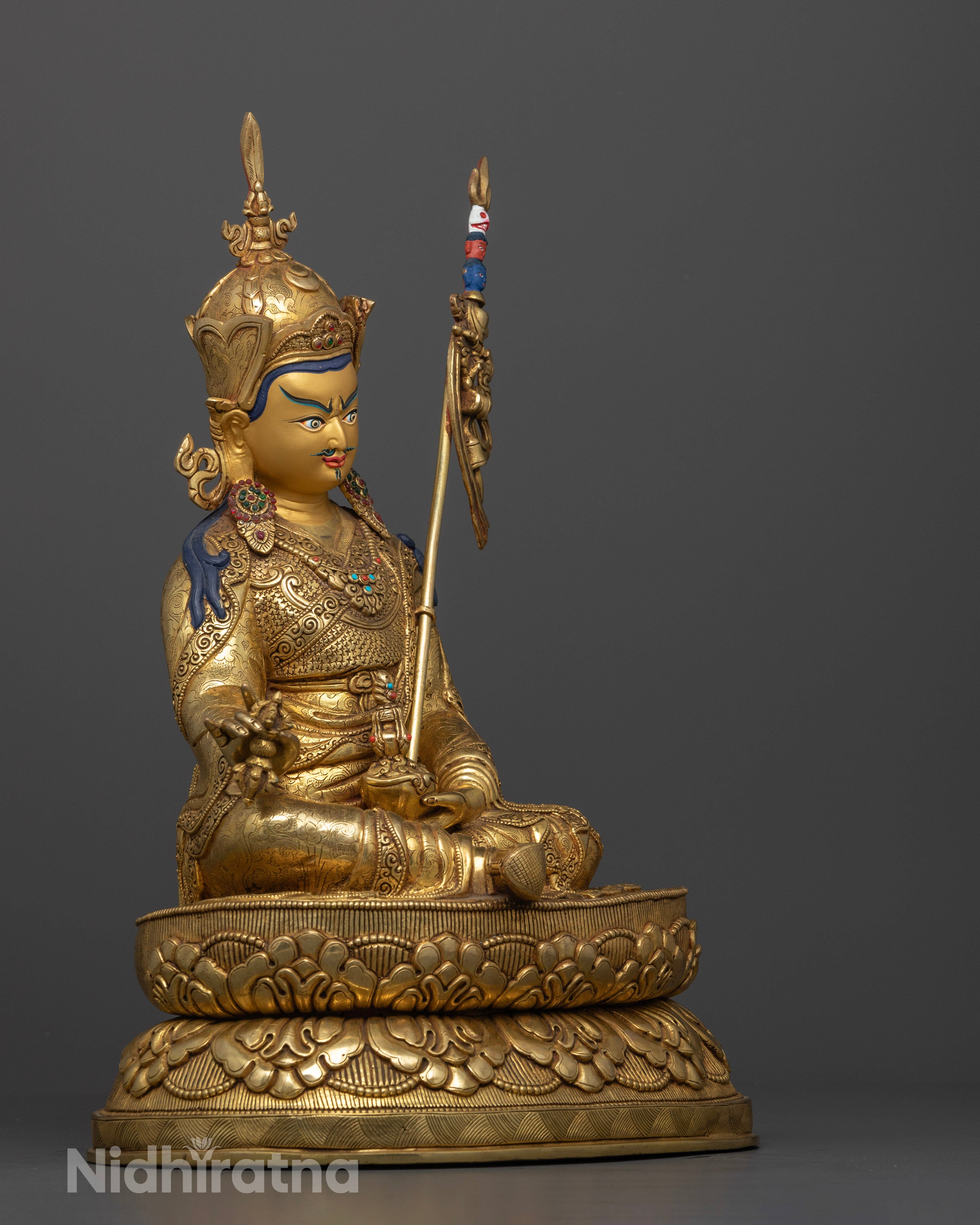 Side view Guru Rinpoche seated on carved lotus pedestal, copper statue with intricate robes, Nepalese Buddhist sculpture