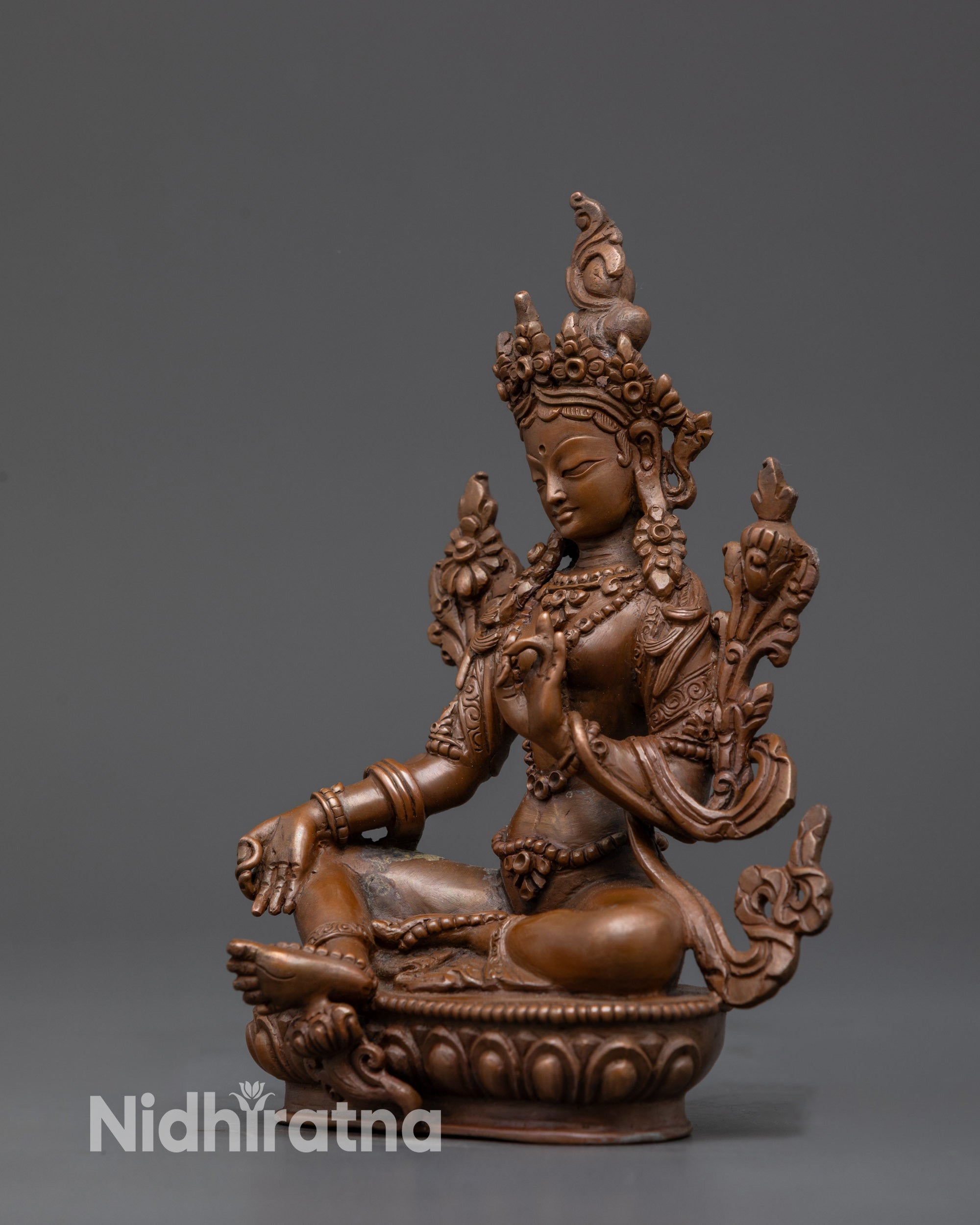 Side view Handcrafted Green Tara sculpture in royal ease mudra holding Utpala flower