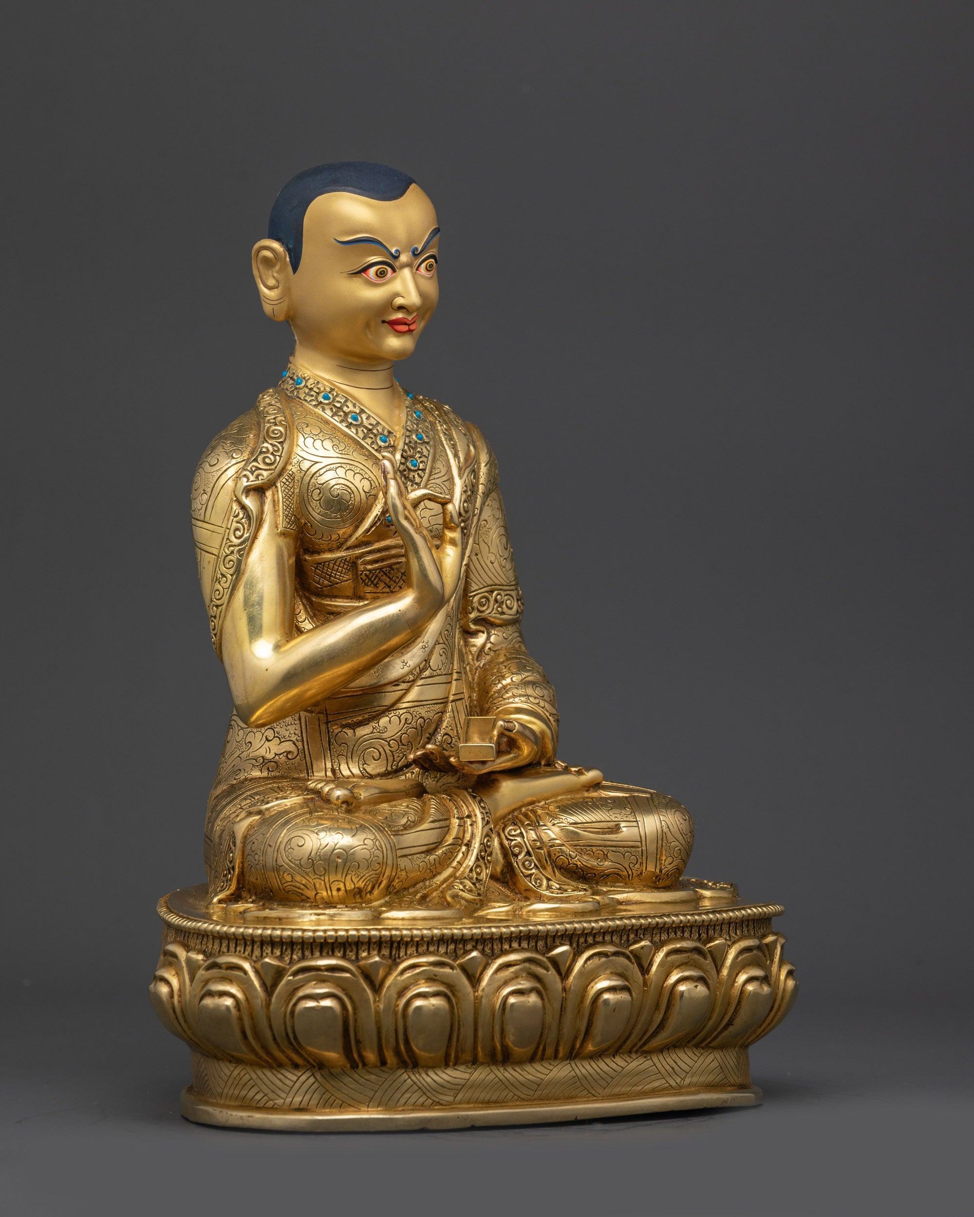 Side view Khedrup Je statue showing finely engraved robes and lotus pedestal