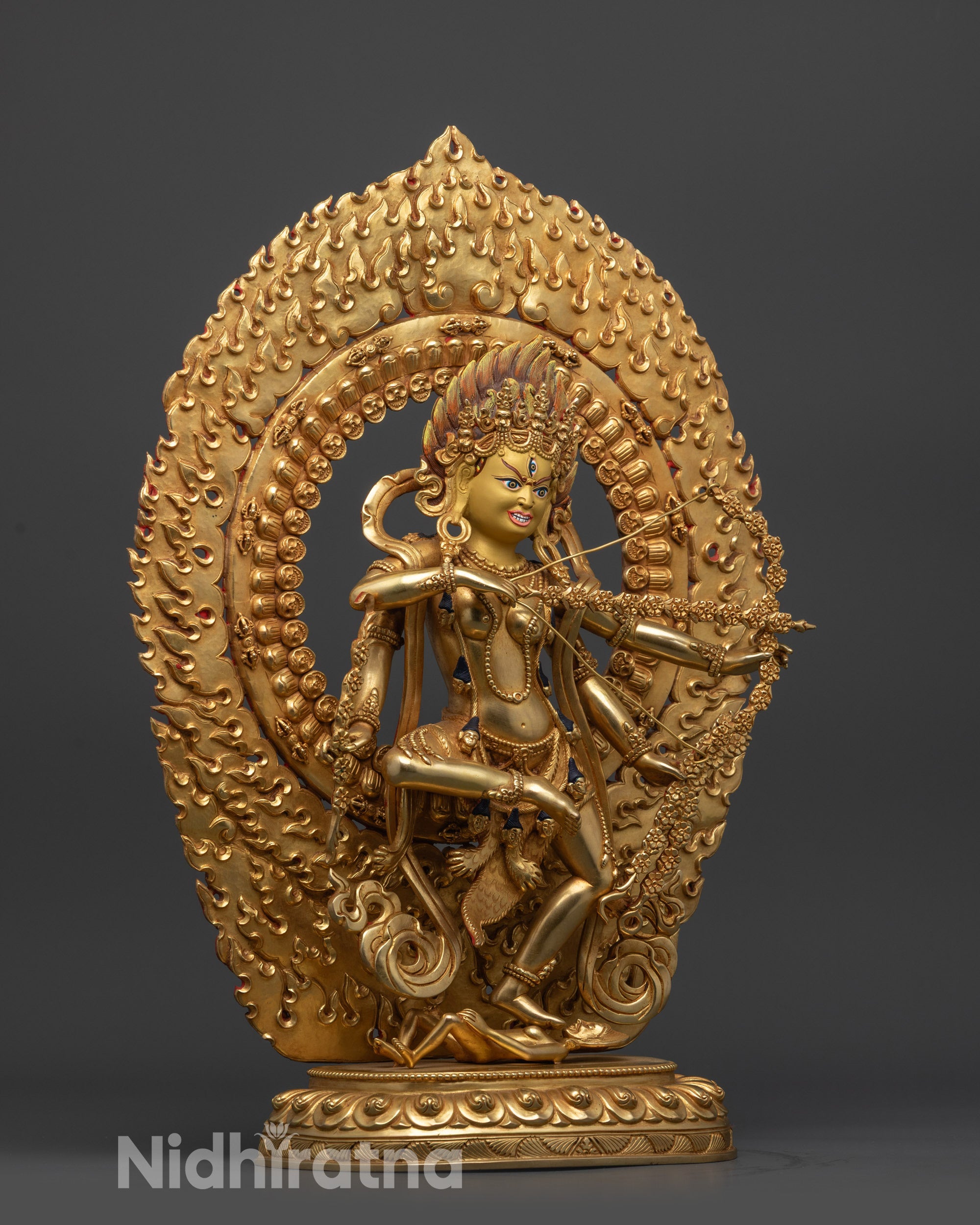 Side view Kurukulla statue with four arms holding bow, arrows, hook, and noose in dynamic pose