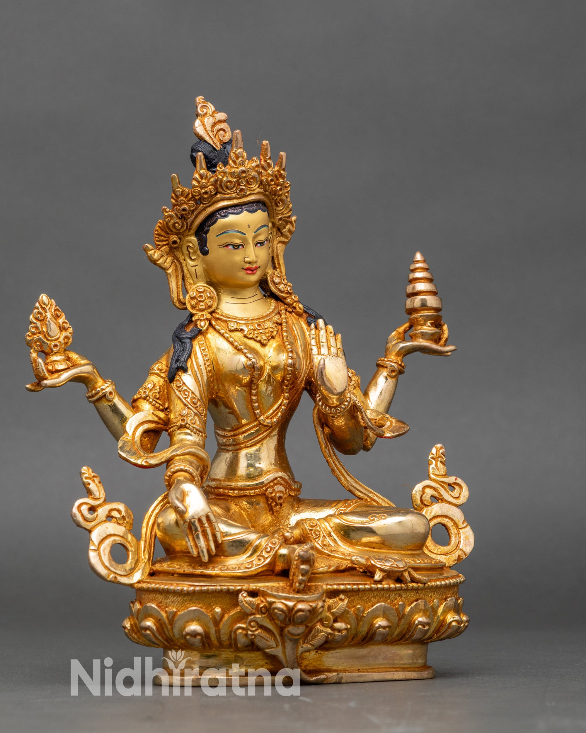 Side view Lakshmi statue with four hands holding lotus, pot of gold, and Varada Mudra