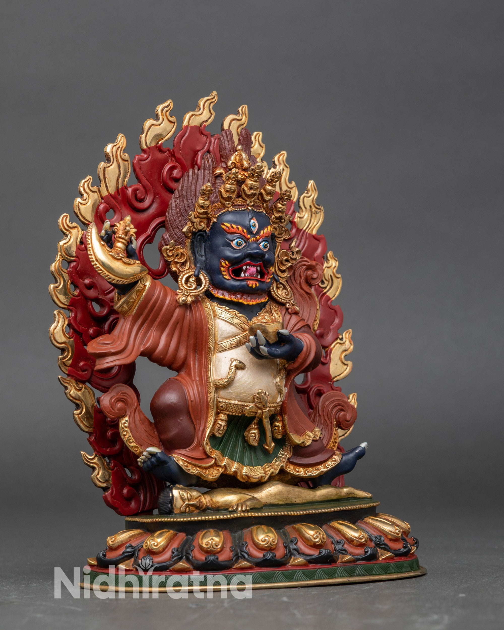 Side view Mahakala Bernagchen sculpture holding curved knife with vajra design, protector deity