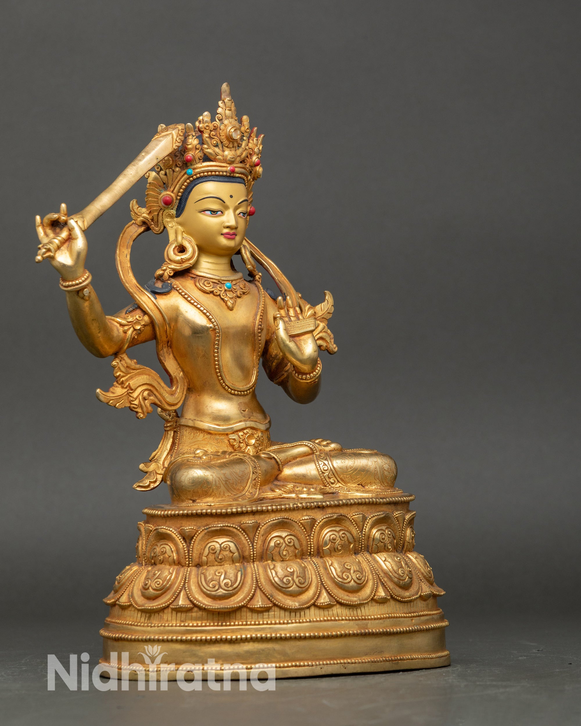 Close up Manjushree gold-painted face with coral stones, Himalayan wisdom bodhisattva