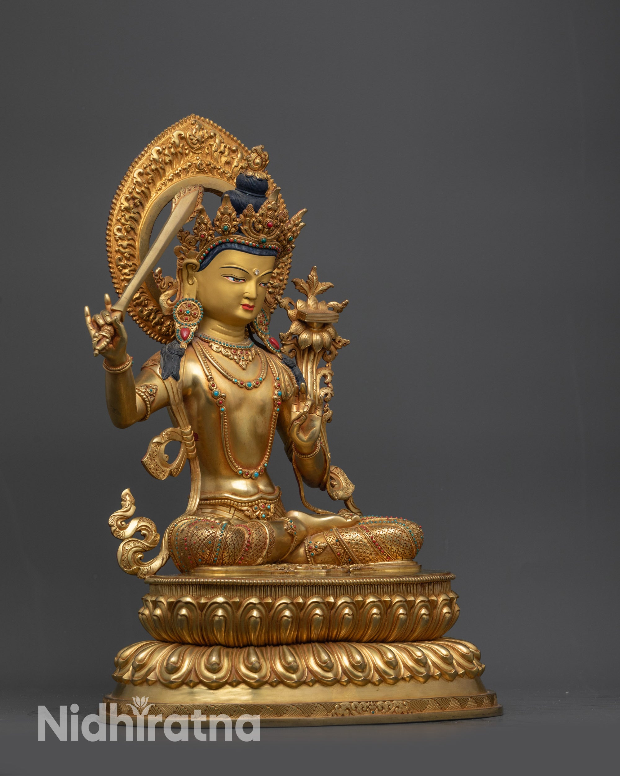 Side view Manjushri Statue showing swirling robe, intricate patterns and sword