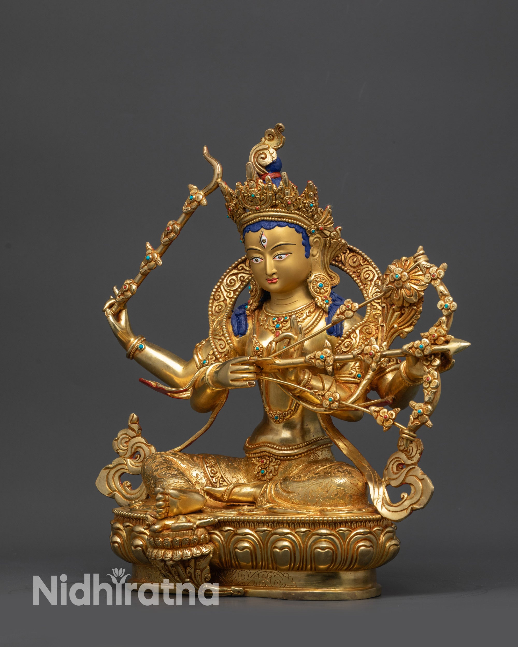 Side view Red Tara Kurukulla Statue seated in royal ease pose on gold-gilded base