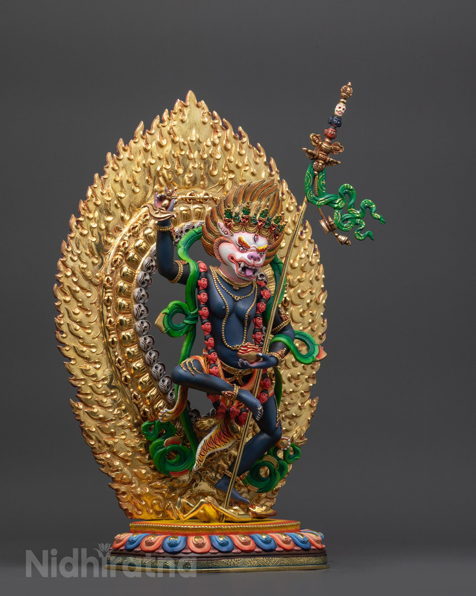 Side view Simha Mukha Statue highlighting kartaika knife, skull cup, and khatvanga staff