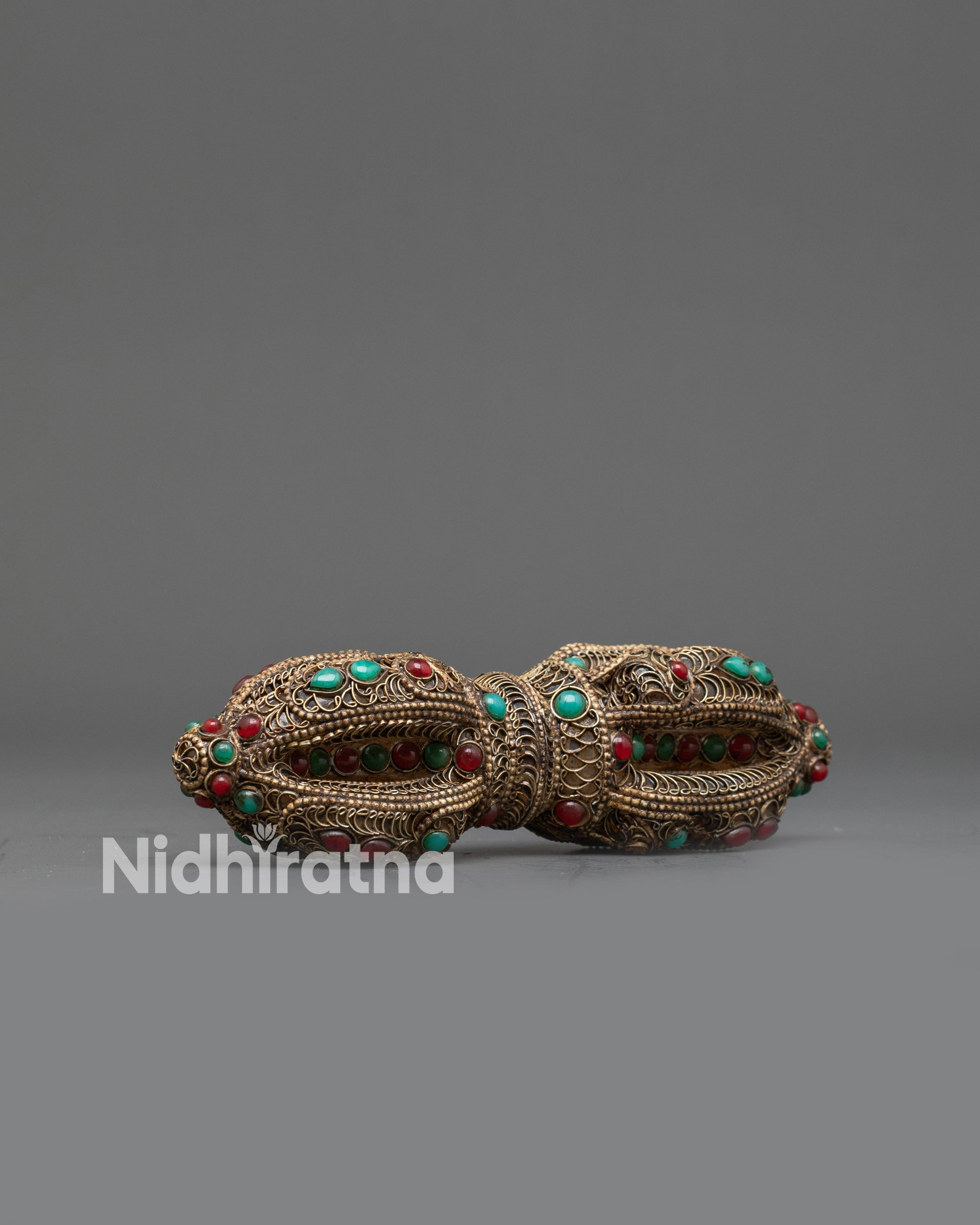 Side view Tibetan Dorje featuring ruby and turquoise stone inlays