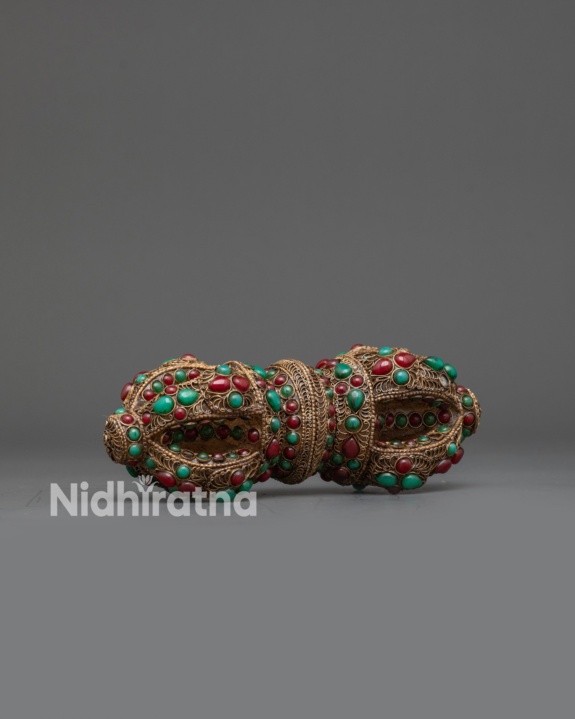 Side view Tibetan Vajra with ornate filigree and gemstone details