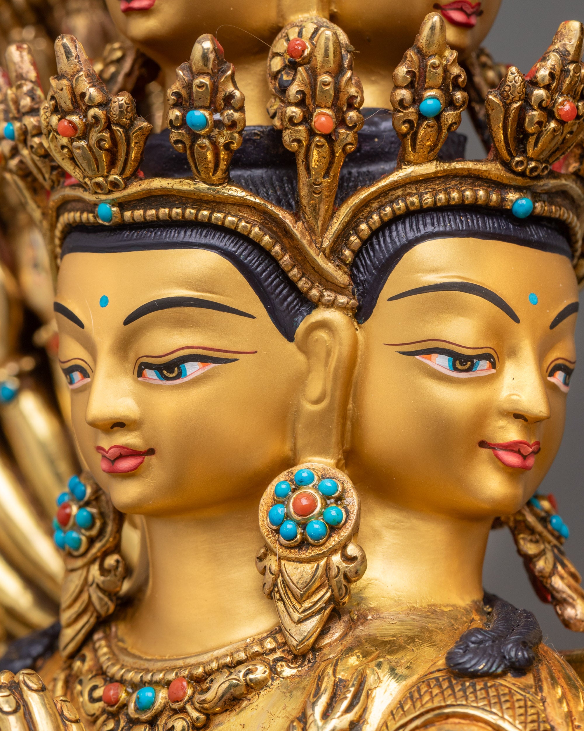 Side view close-up of Chenrezig statue highlighting intricately crafted arms and ornate halo, copper and gold Himalayan artwork