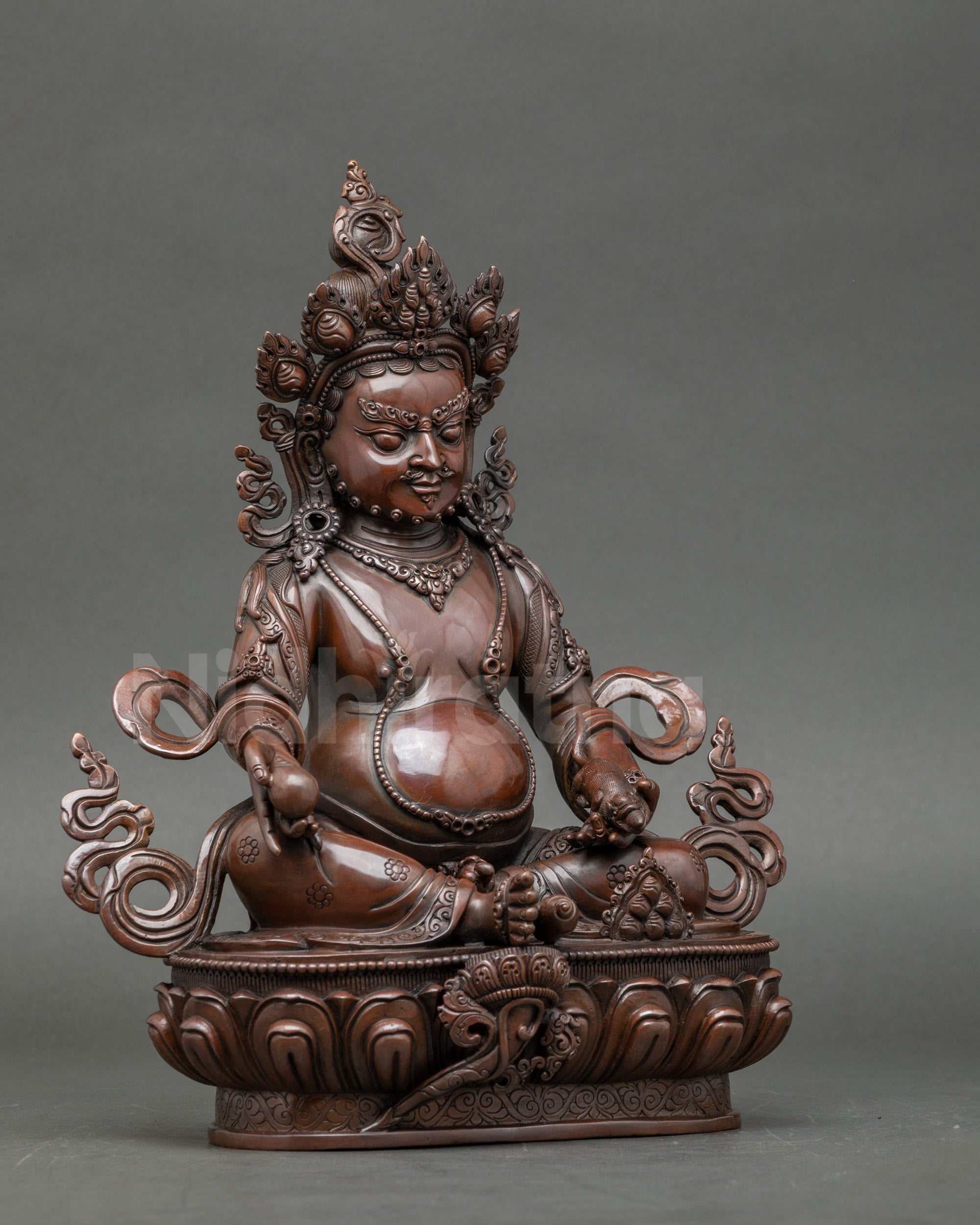 Side view copper Dzambhala statue with flowing decorative elements, symbolizing wealth and generosity