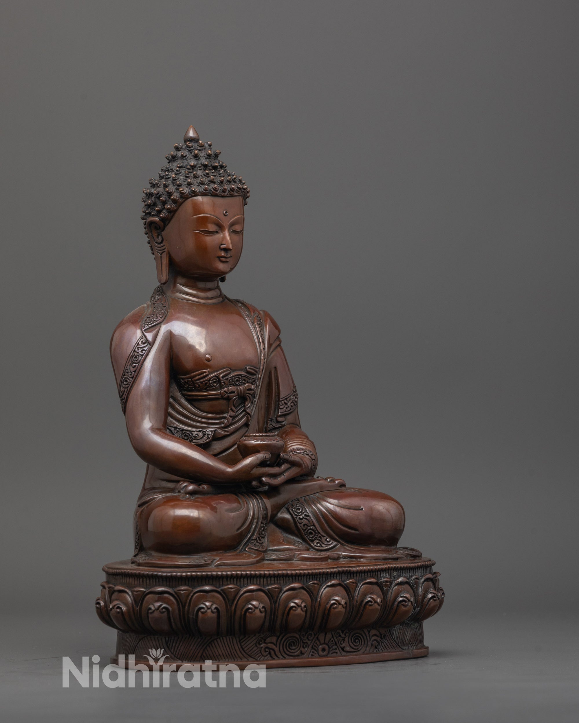 Side view of Amitabha Buddha statue with monk’s robe and intricately carved lotus base