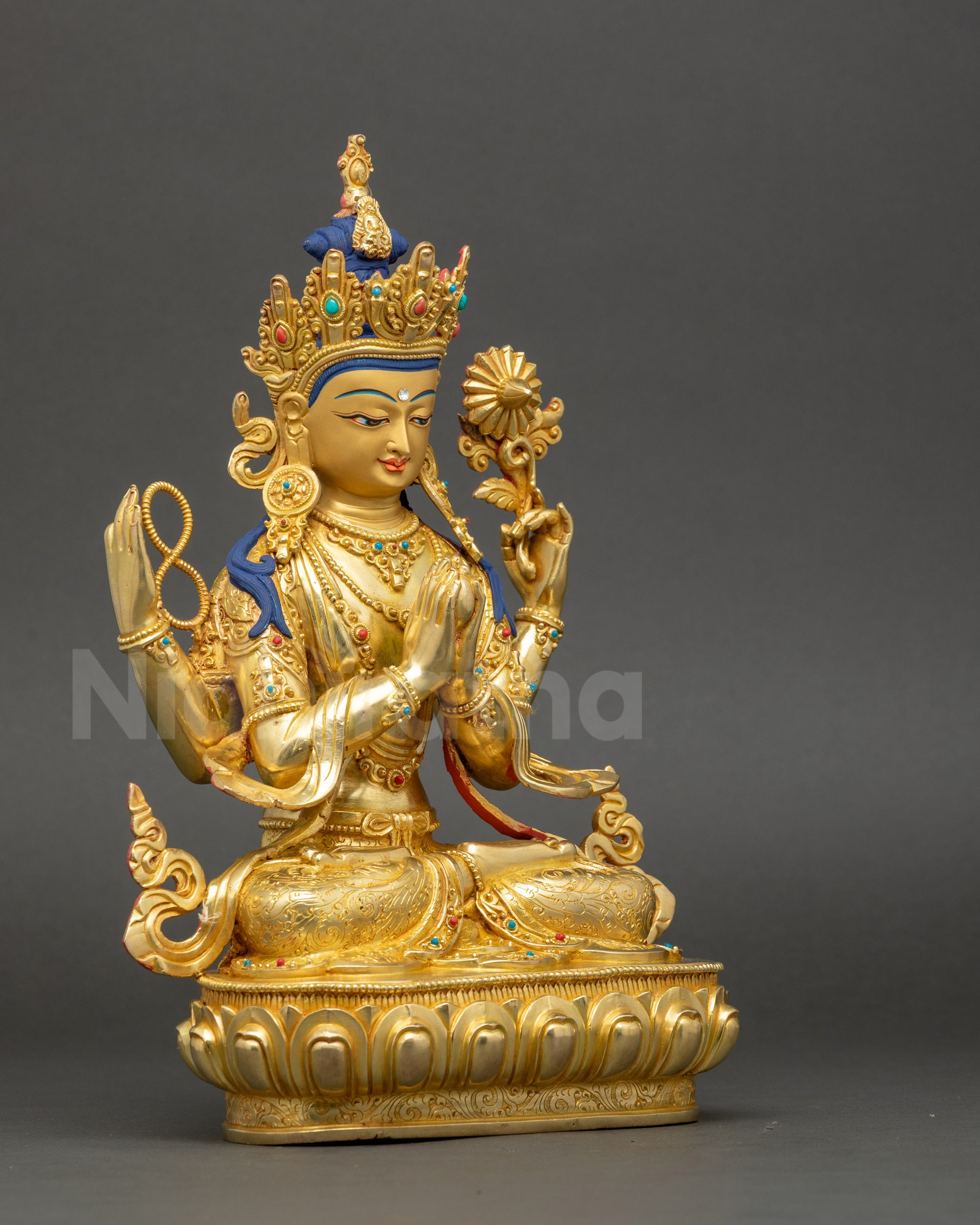 Side view of Chenrezig statue showing lotus throne and four arms holding sacred symbols