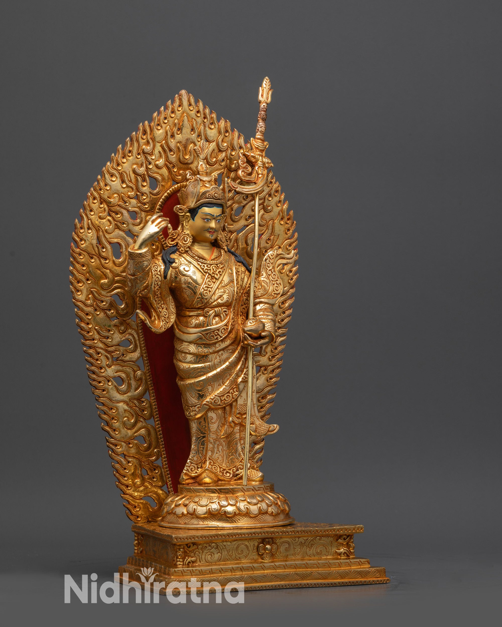 Side view of Fire gold-gilded Guru Rinpoche holding vajra and khatvanga trident