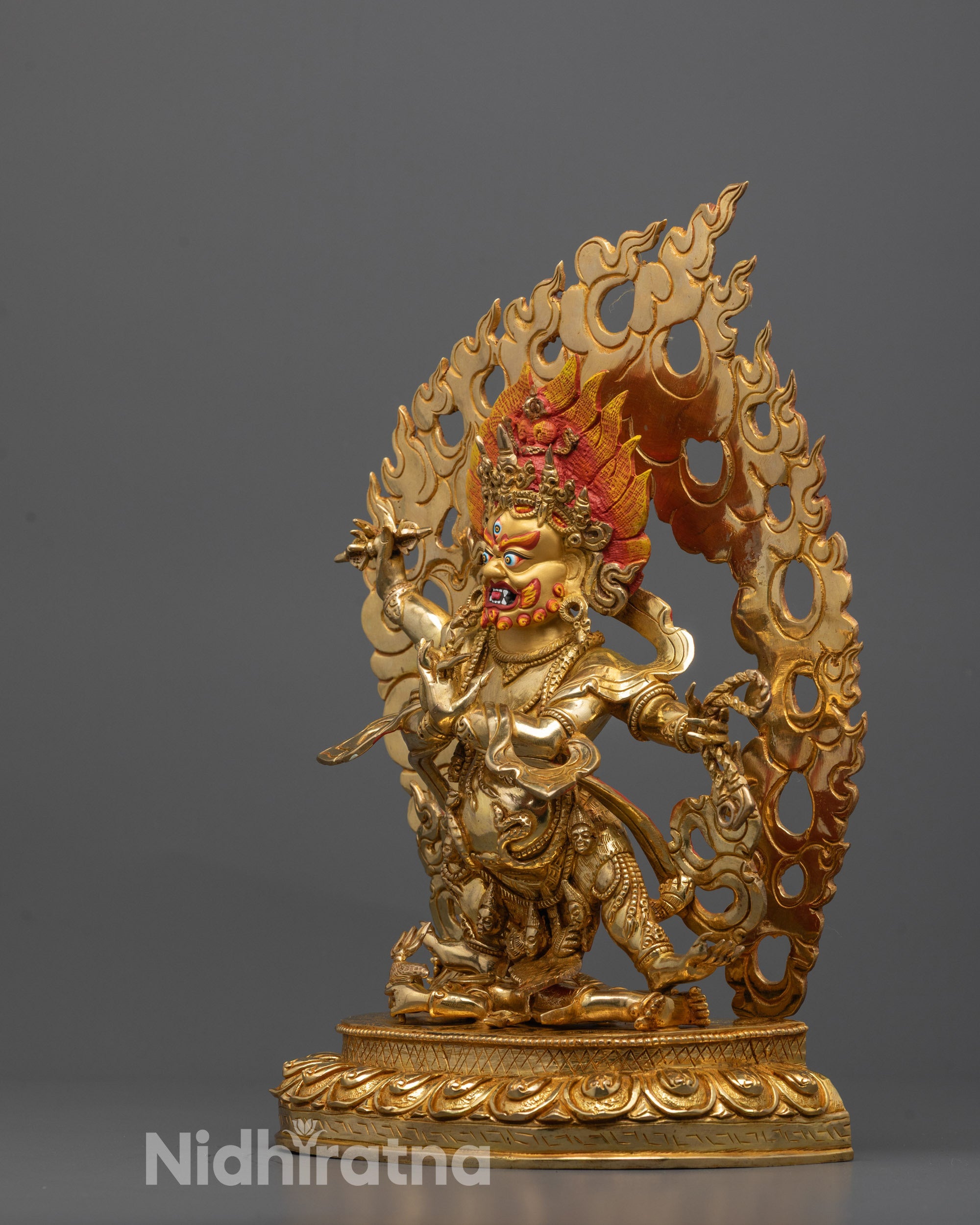 Side view of Four-Armed Vajrapani Standing on Subdued Figure on Lotus Base
