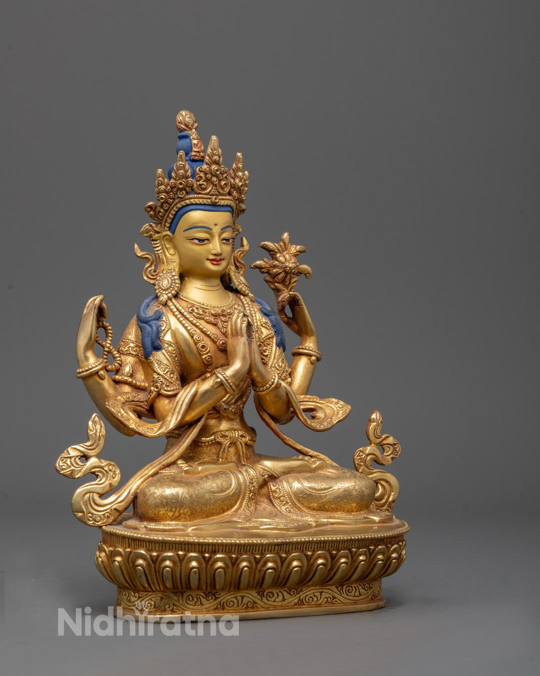 Side view of Four-armed Chenrezig holding prayer beads and lotus flower