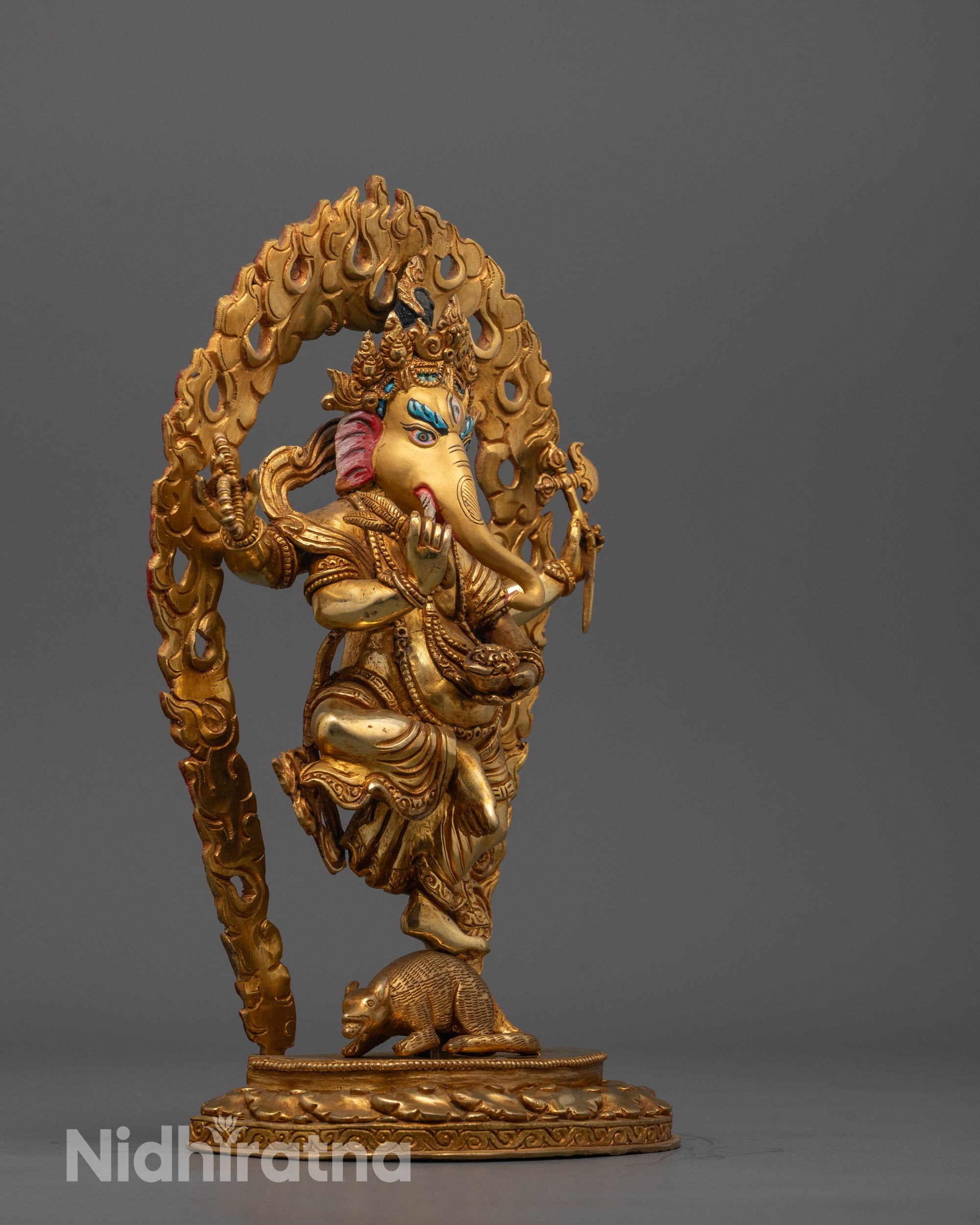 Side view of Ganesh Statue in gilded copper with mouse mount and intricate halo