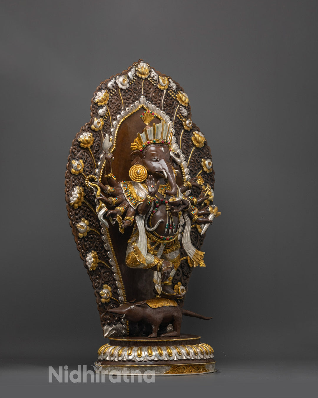 Side view of Ganesha statue standing on lotus base and mouse