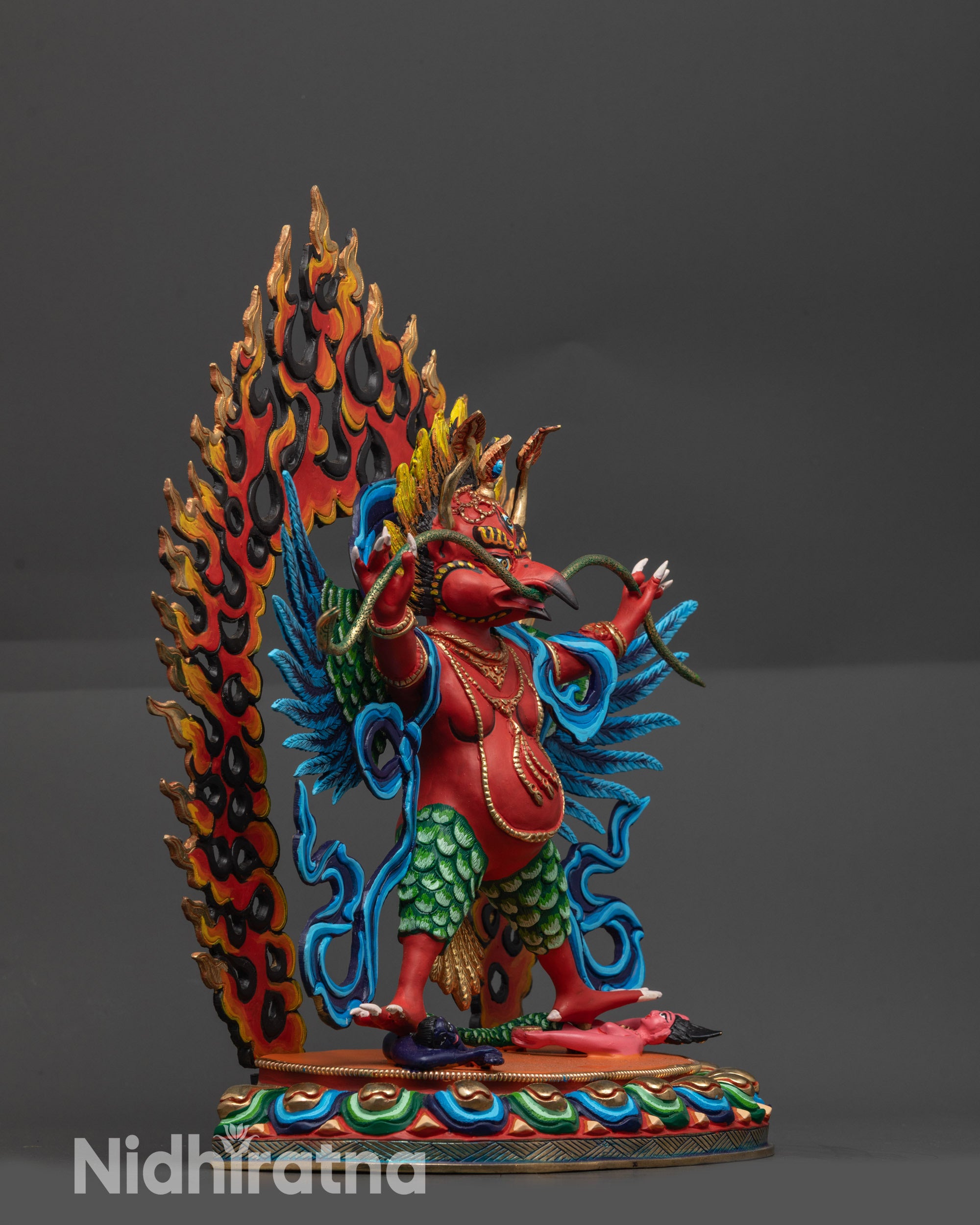 Side view of Garuda holding serpent and sacred objects with detailed feathers