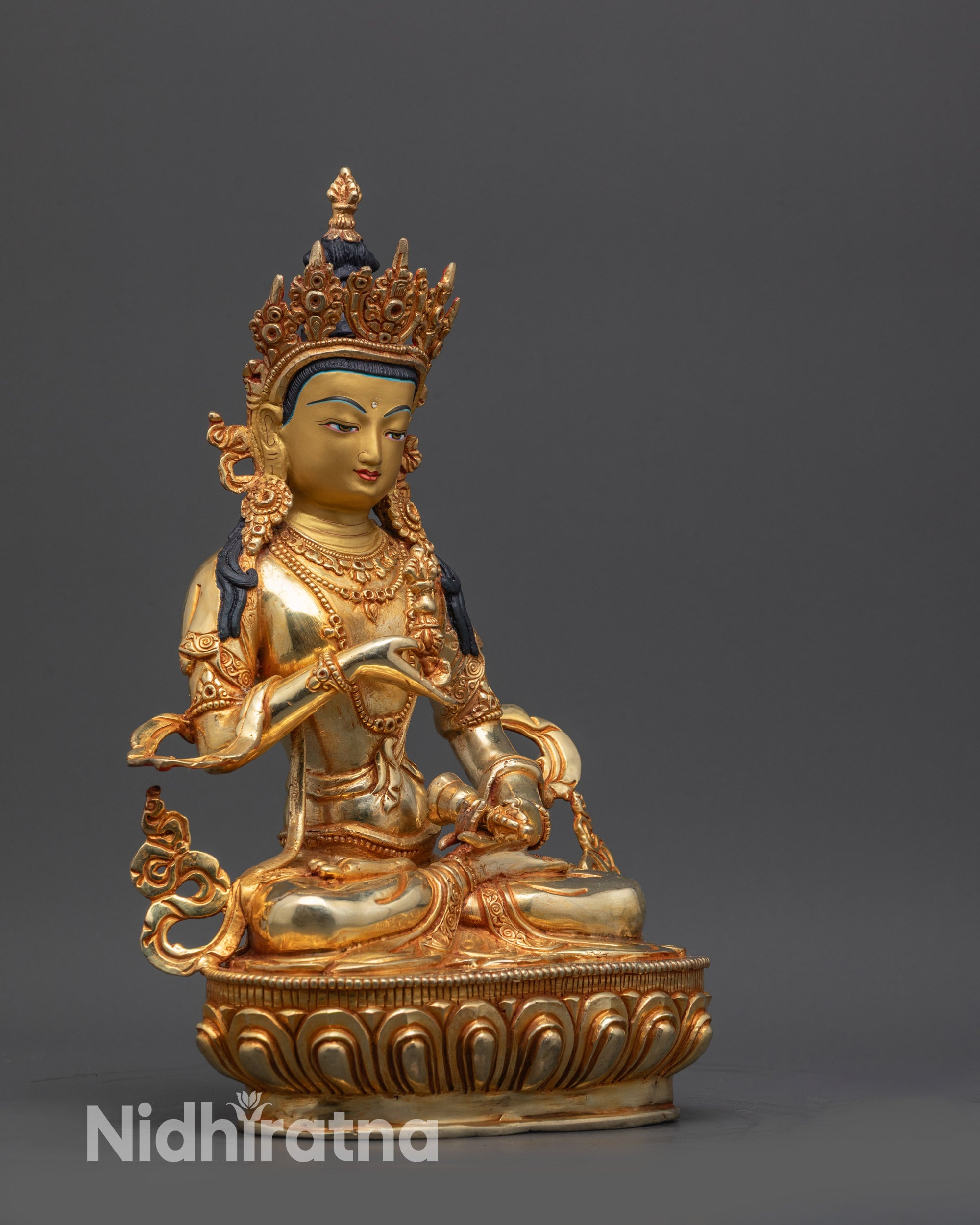 Side view of Golden Vajrasattva sculpture with flowing robes and detailed jewelry on lotus seat