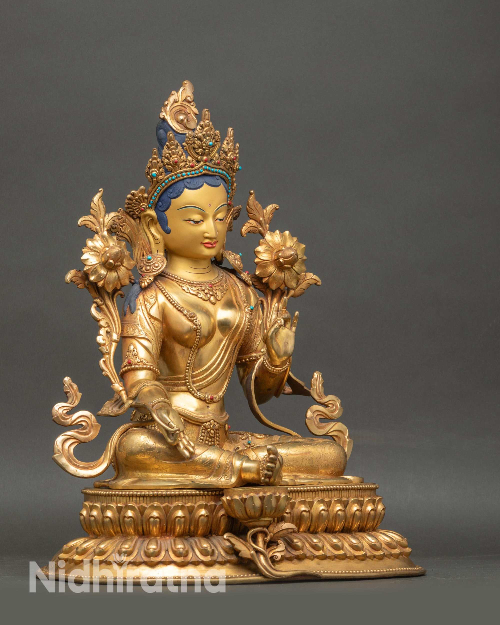 Side view of Green Tara statue with flowing robe and semi-precious stone details