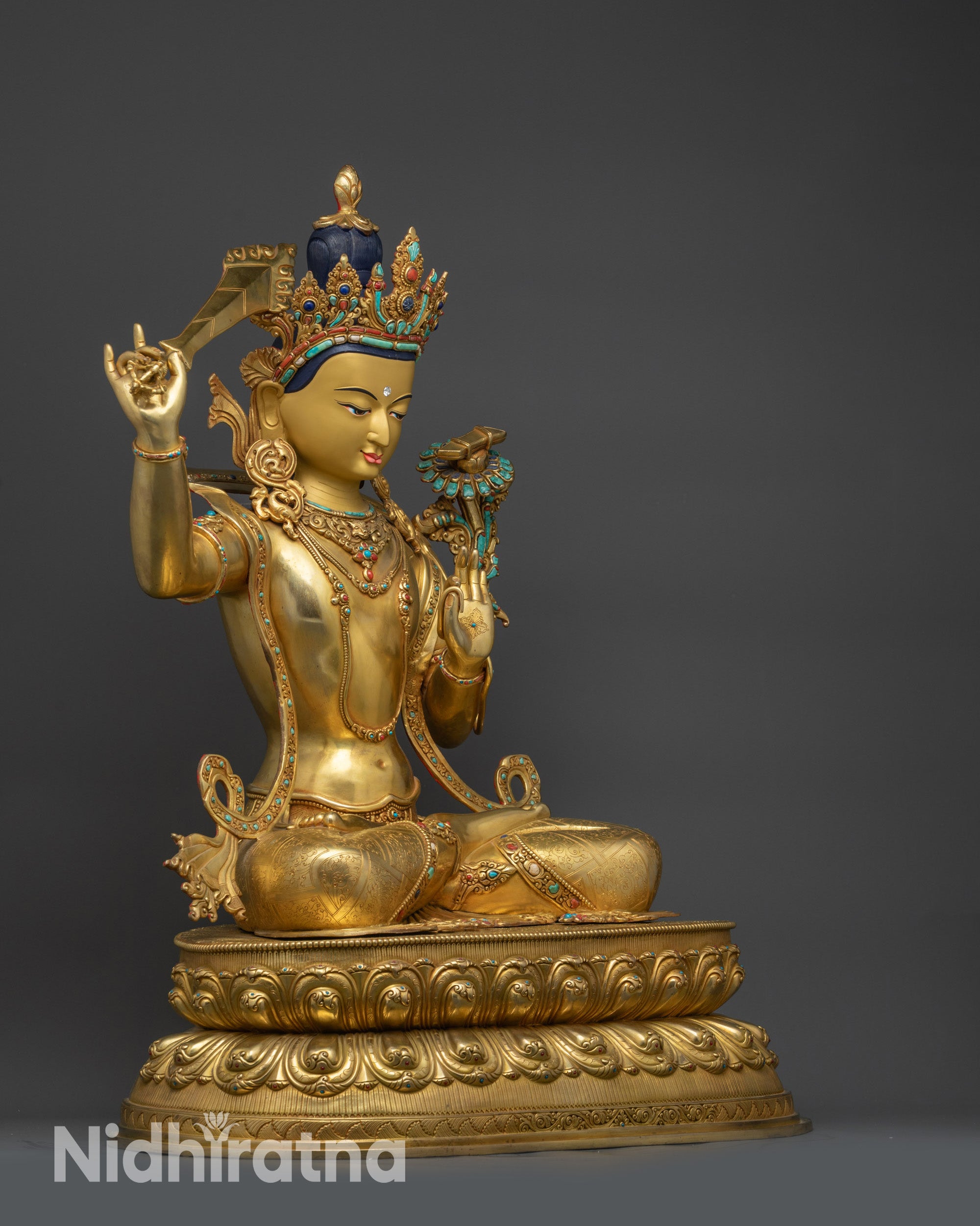 Side view of Manjushri statue holding double-edged sword with wisdom flame