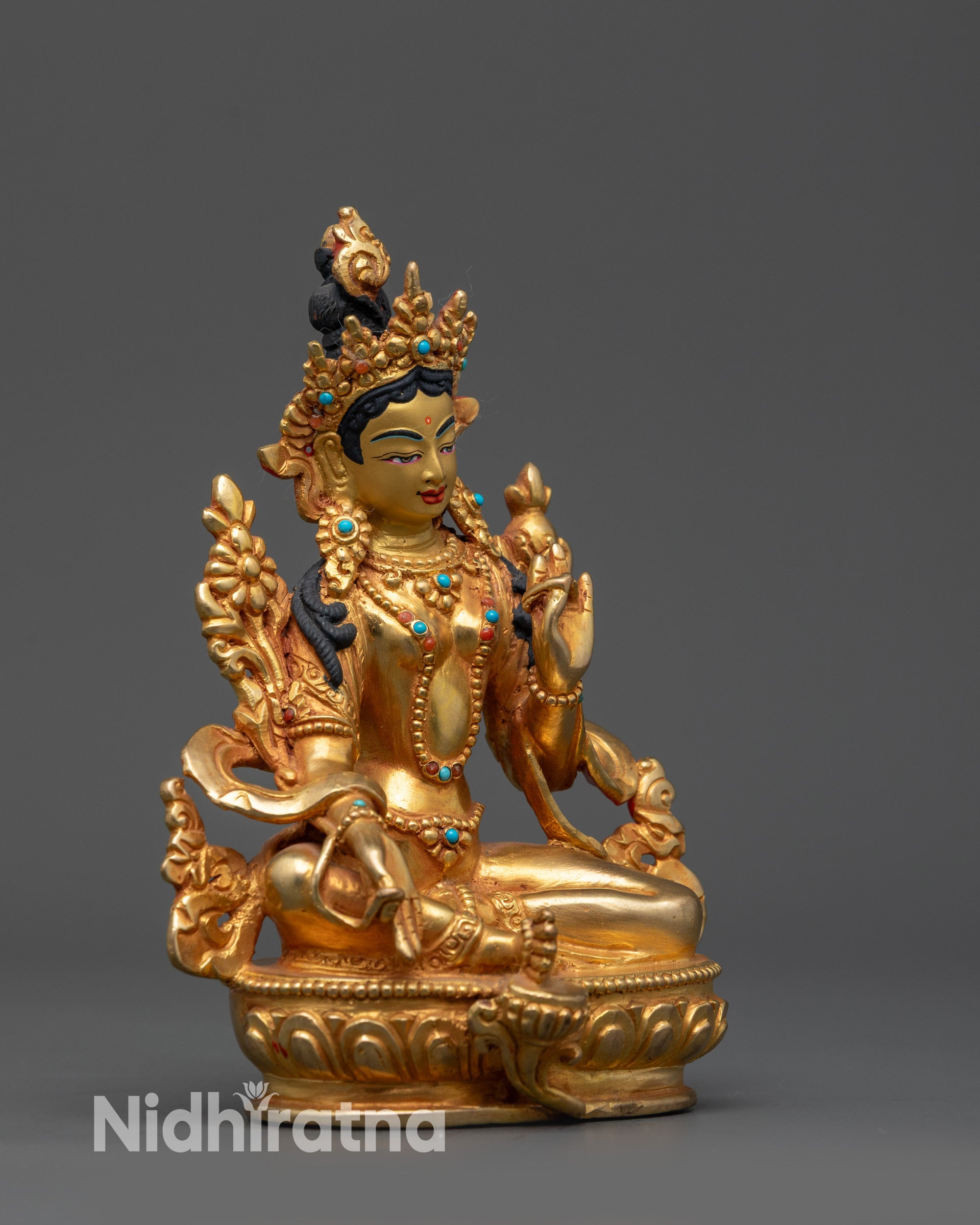 Side view of Mother Tara sculpture with varada and abhaya mudra, lotus motifs visible