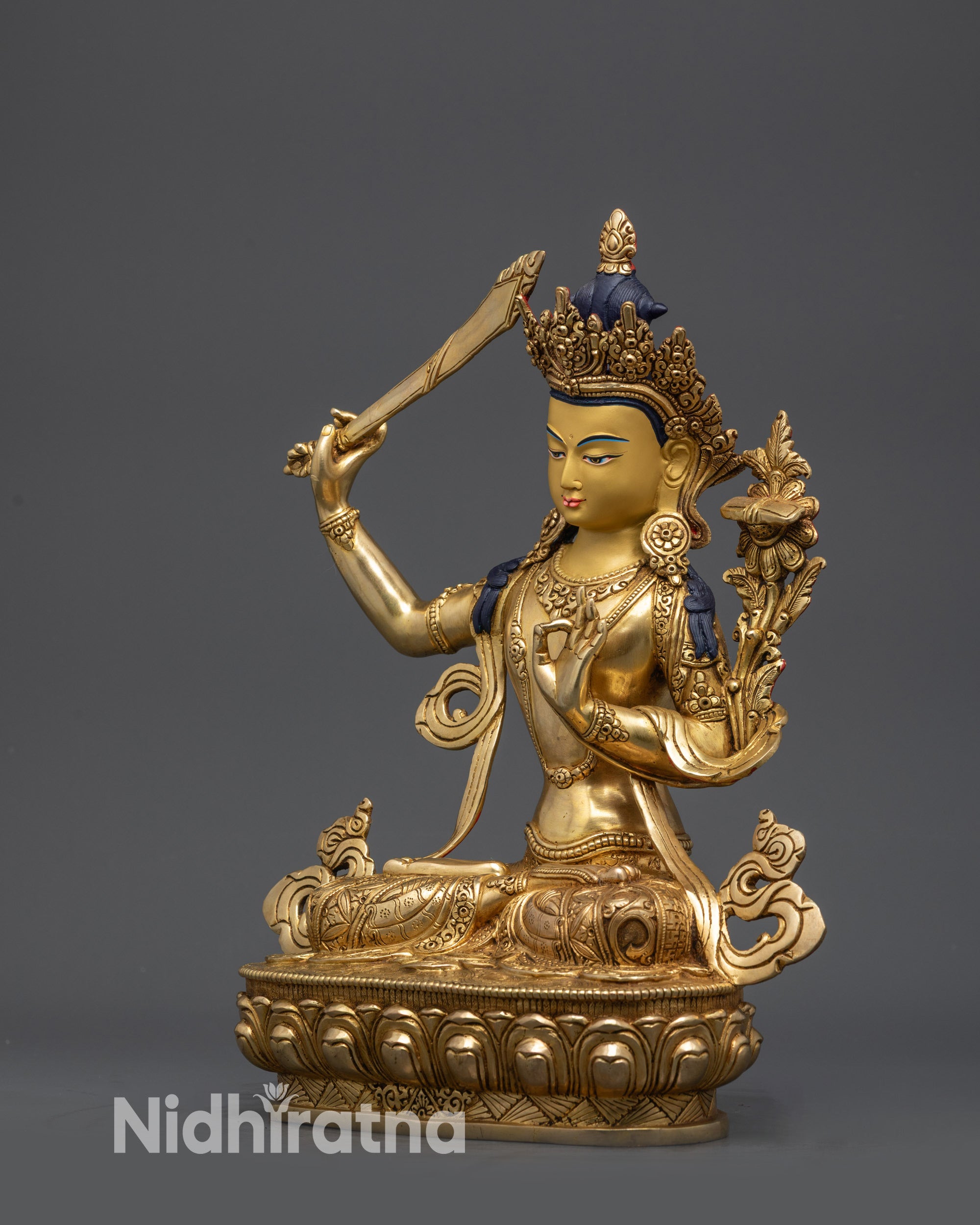 Side view of Nepalese handcrafted Manjushri Statue with swirling patterned garments