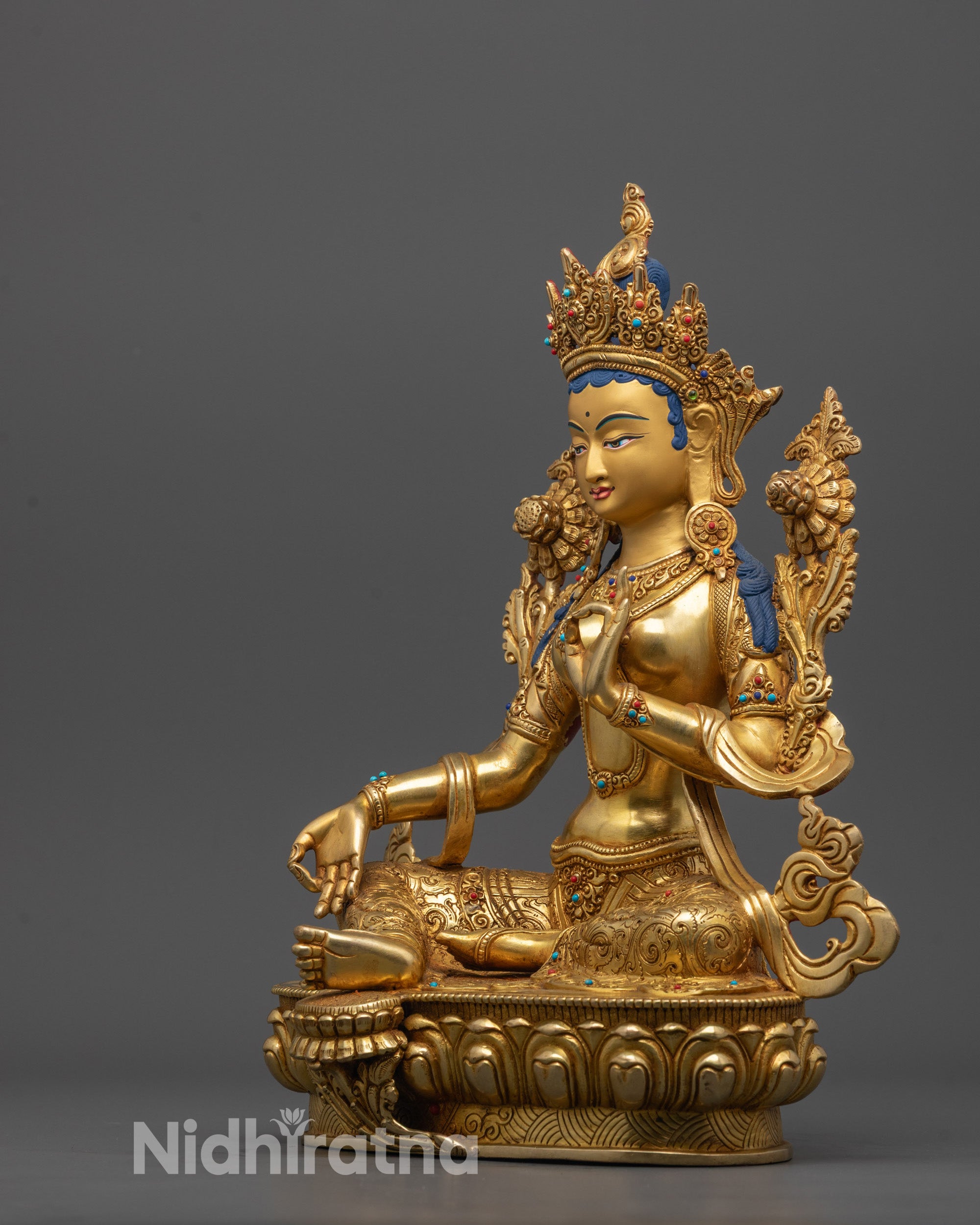 Side view of Skilled Nepalese artisan creating Green Tara Statue using traditional method